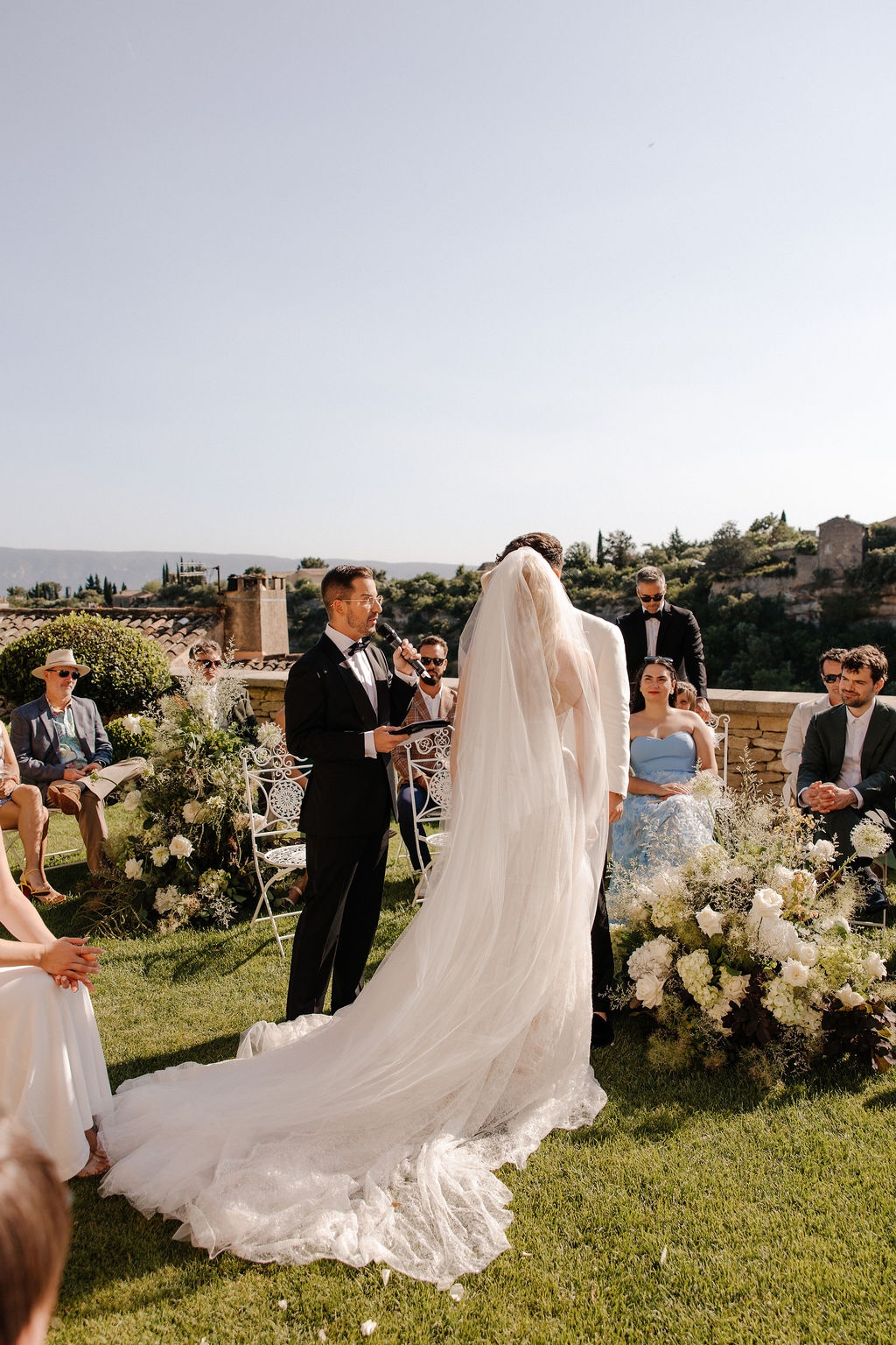 Bride from behind with veil during ceremony at Airelles Gordes La Bastide, Provence