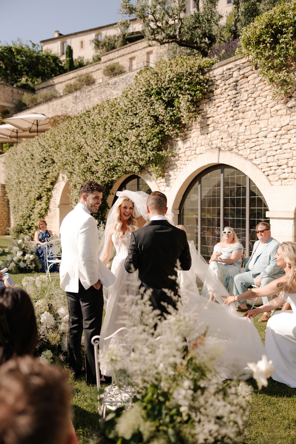 Couple smiling at altar before stone arches at Airelles Gordes La Bastide, Provence