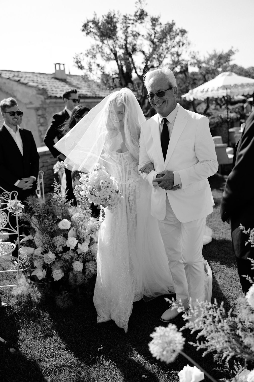 Black and white bride walks down aisle with father at Airelles Gordes La Bastide, Provence