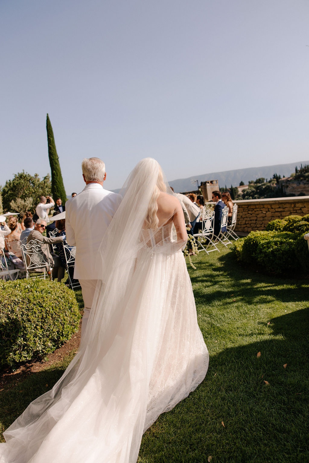 Bride and father walking down ceremony aisle at Airelles Gordes La Bastide, Provence