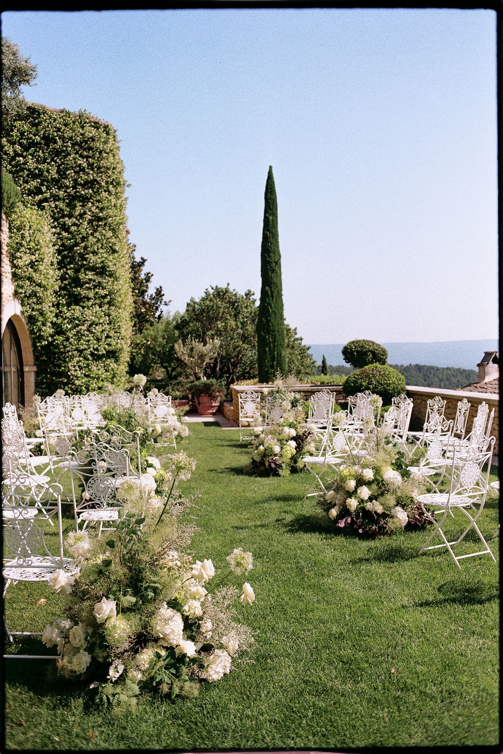 Empty ceremony aisle with hydrangeas and cypress at Airelles Gordes La Bastide, Provence