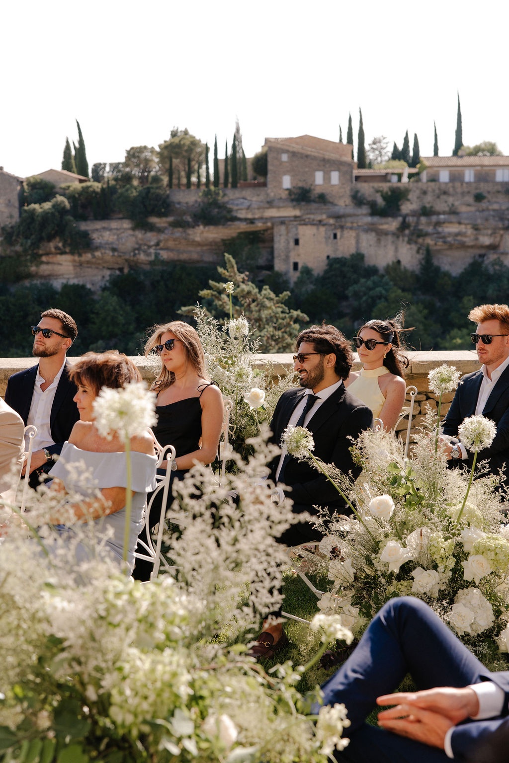 Guests seated at outdoor ceremony with Gordes village view at Airelles Gordes La Bastide, Provence