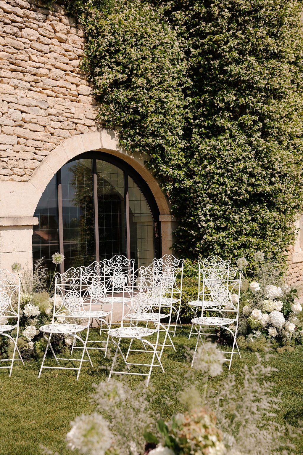 White iron chairs beside arched window at Airelles Gordes La Bastide, Provence
