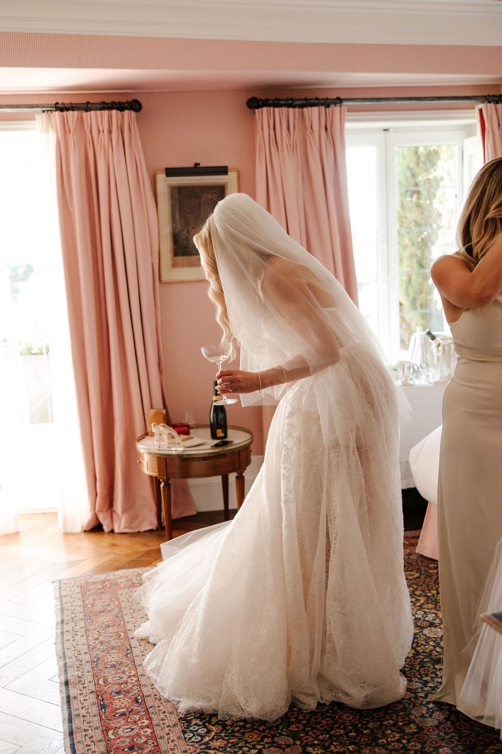 Bride with champagne in getting-ready suite at Airelles Gordes La Bastide, Provence