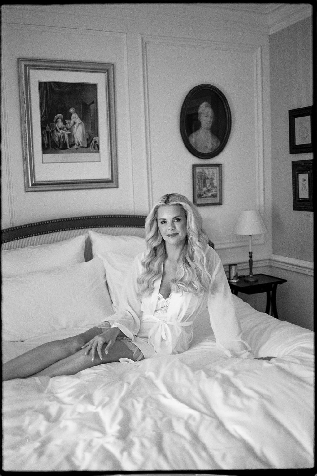 Bride on bed in silk robe before dress at Airelles Gordes La Bastide, Provence