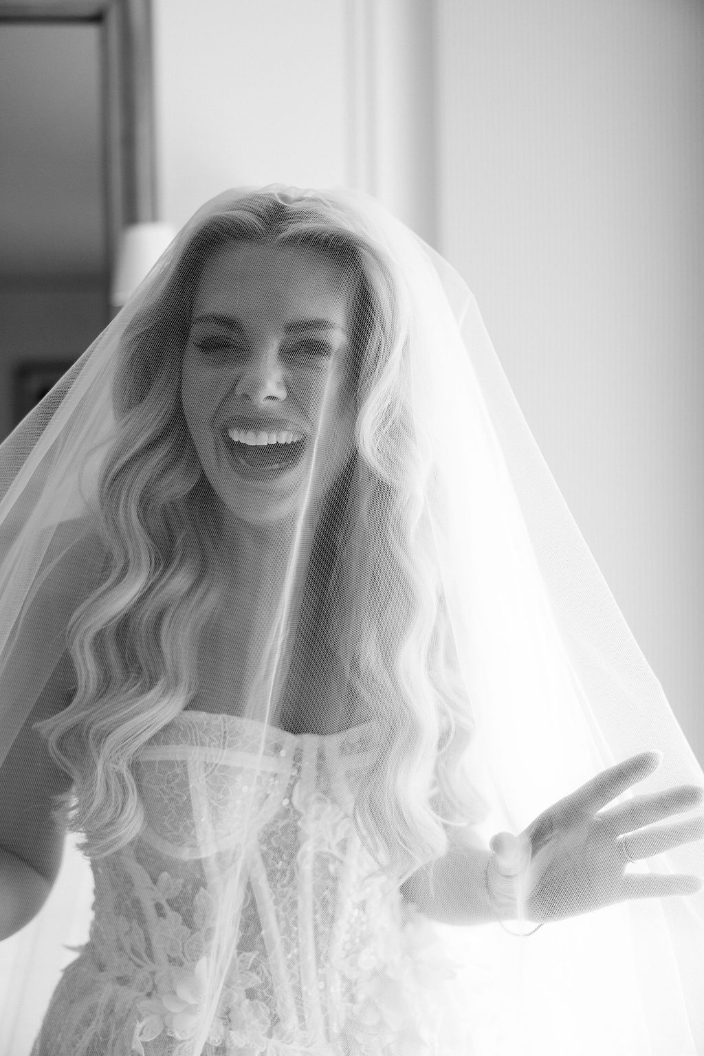 Bride laughing under tulle veil at Airelles Gordes La Bastide, Provence