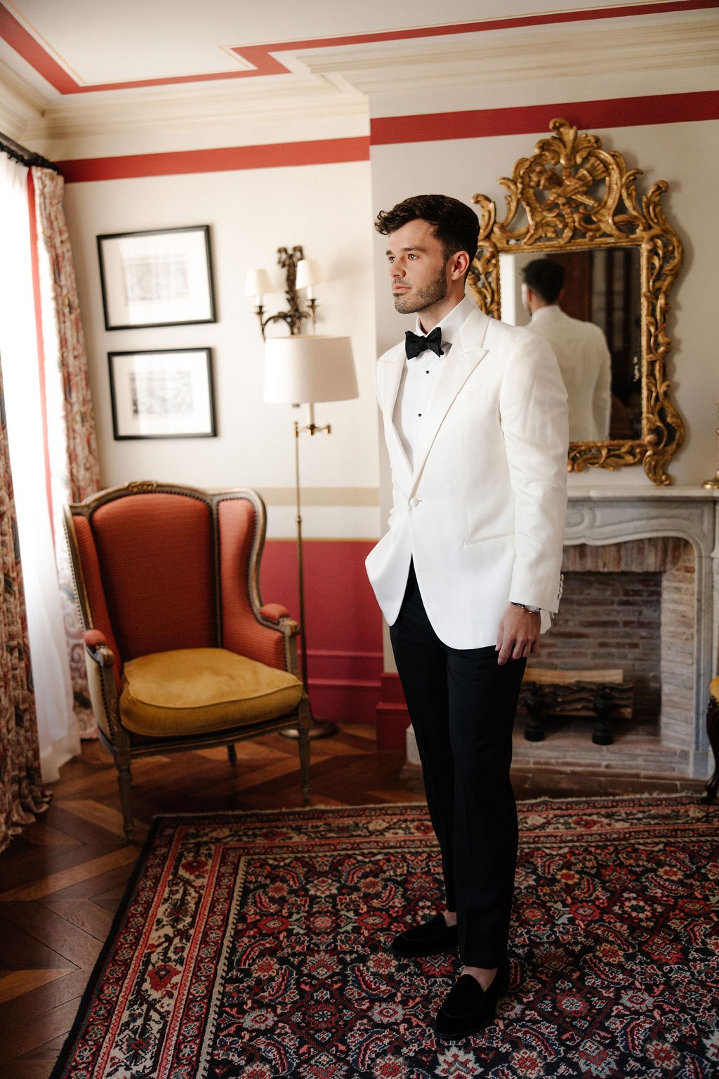 Groom in white dinner jacket in vintage suite at Airelles Gordes La Bastide, Provence