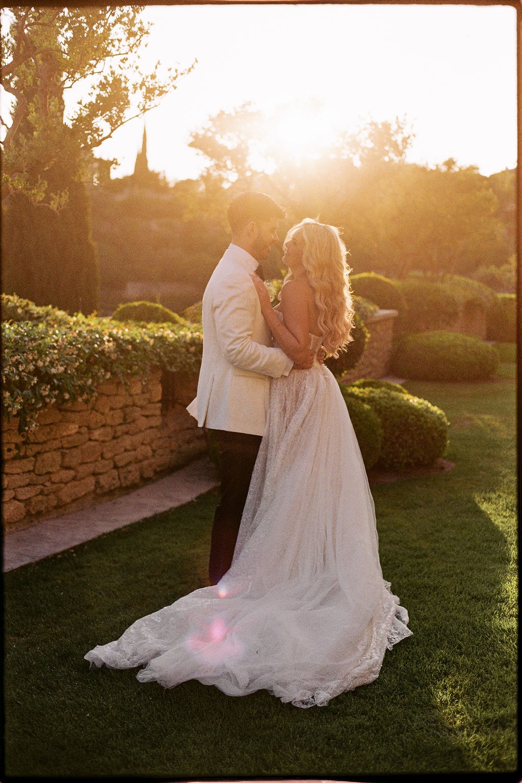 Couple embracing at golden hour in garden at Airelles Gordes La Bastide, Provence