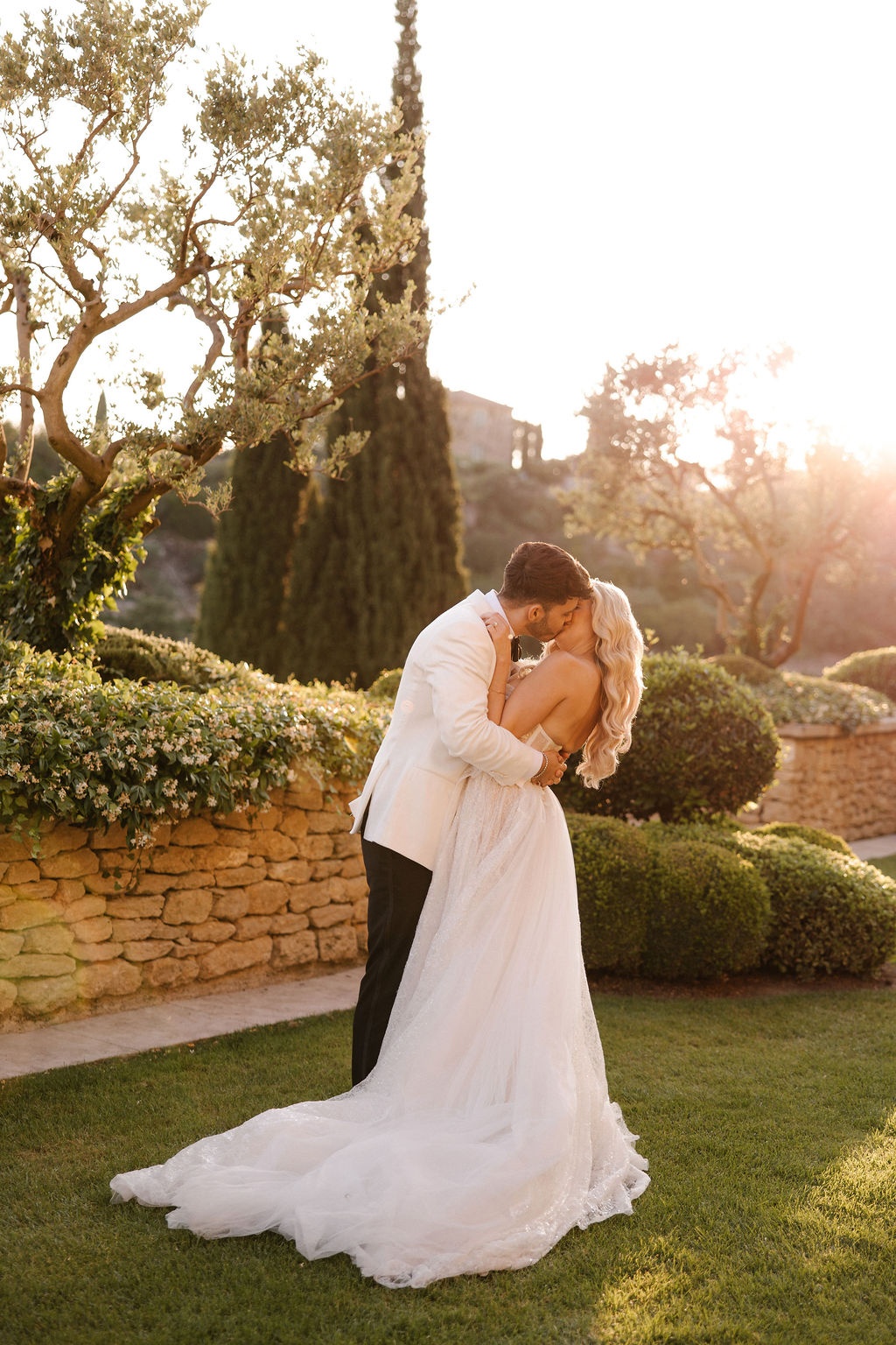 Couple kissing at golden hour with olive tree at Airelles Gordes La Bastide, Provence