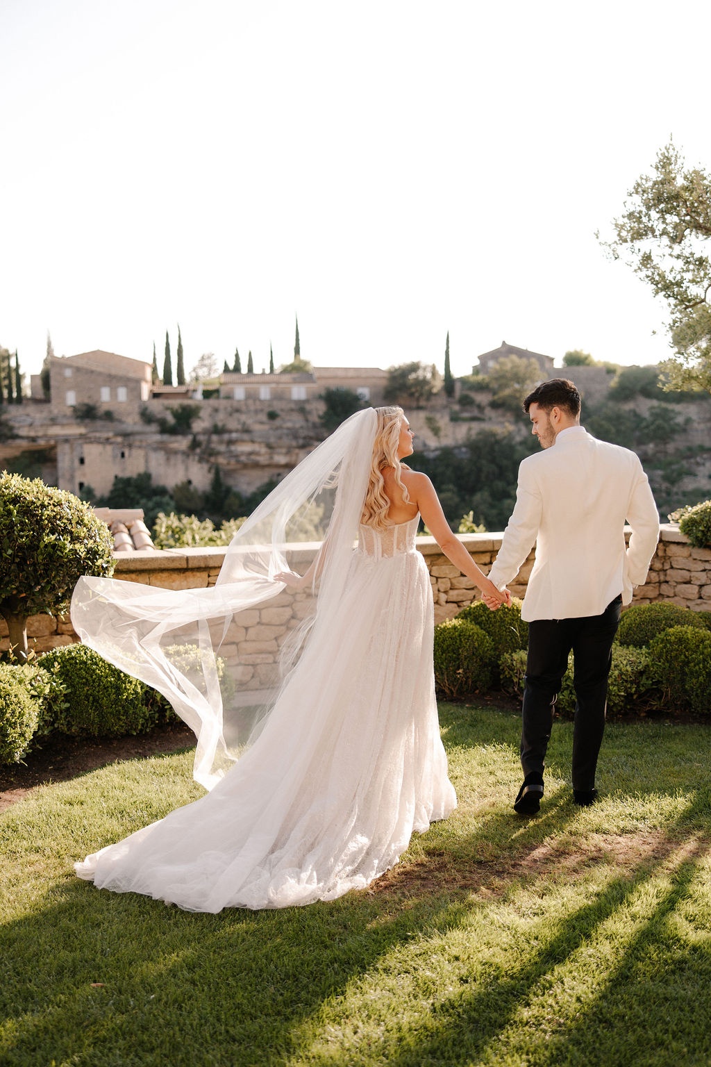 Couple walking with veil overlooking Gordes at Airelles Gordes La Bastide, Provence