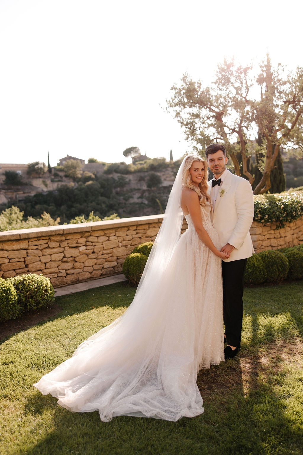 Couple holding hands at golden hour with Gordes view at Airelles Gordes La Bastide, Provence