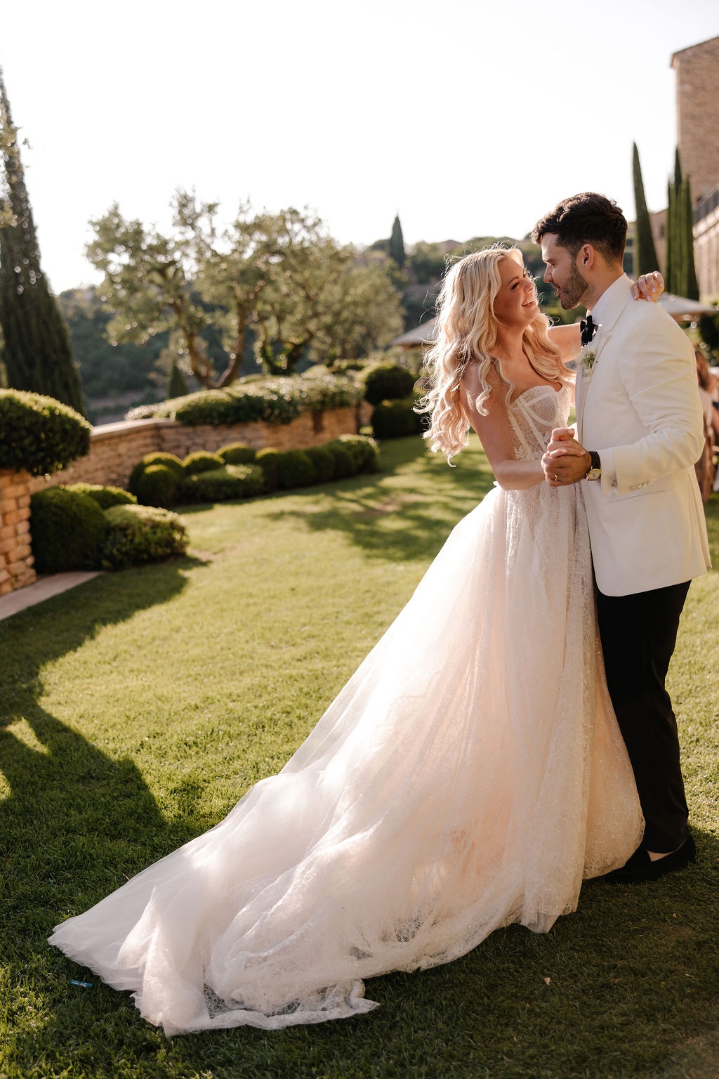 Couple dancing at golden hour on garden lawn at Airelles Gordes La Bastide, Provence
