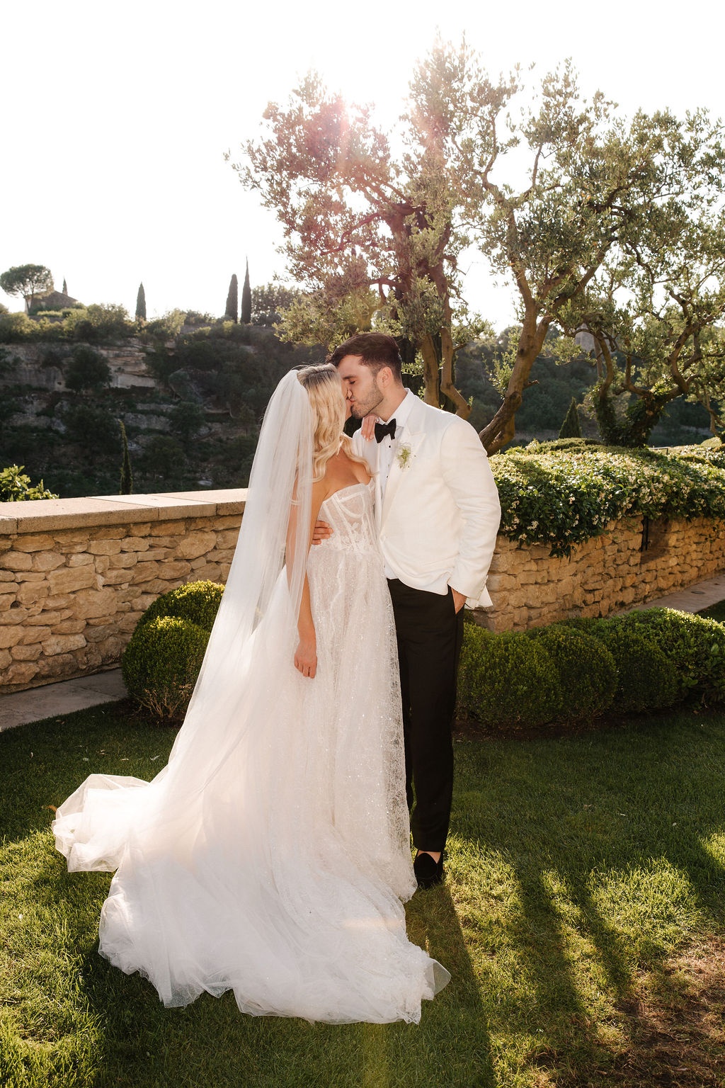 Couple kissing at golden hour in garden at Airelles Gordes La Bastide, Provence