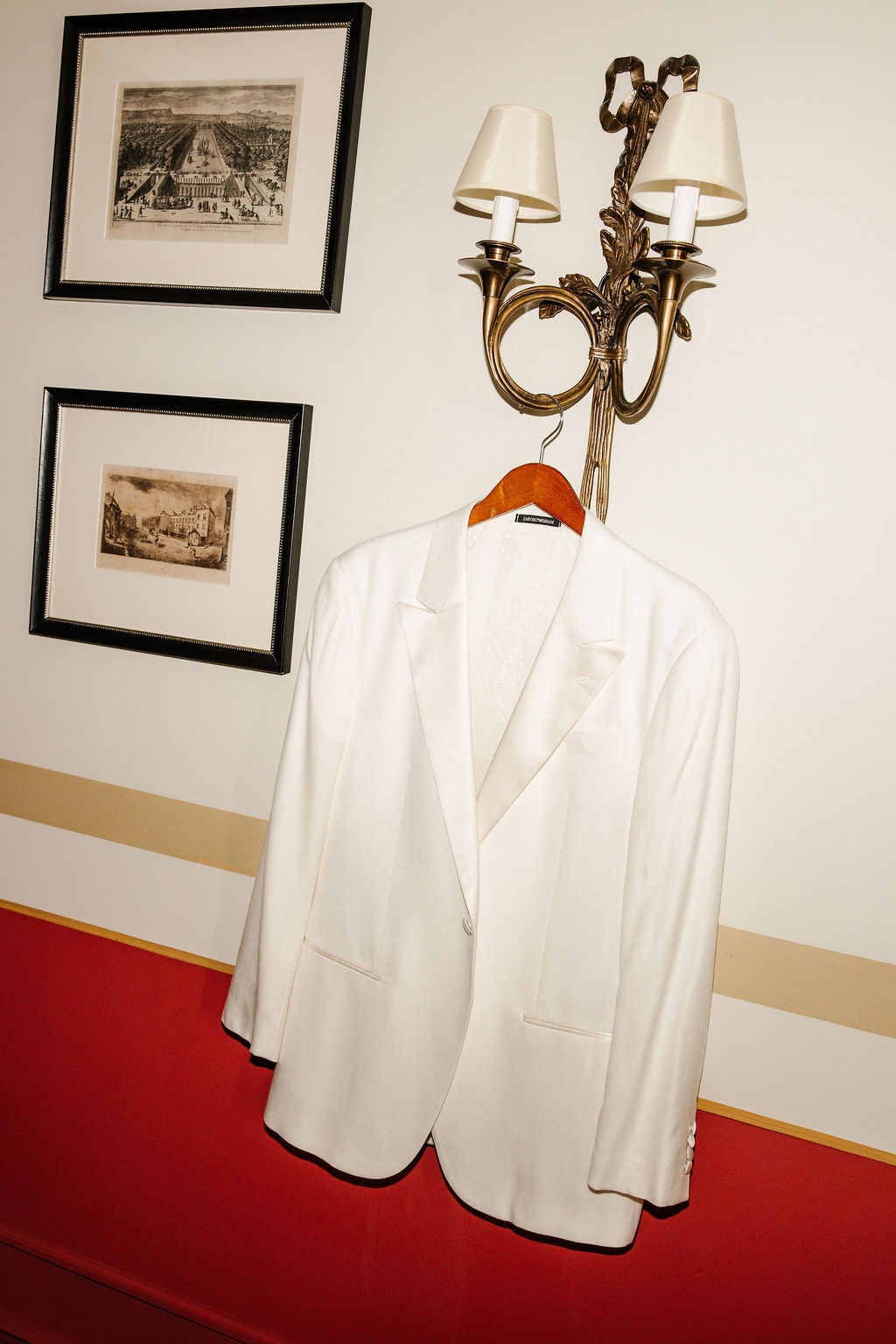 Groom's Armani jacket hanging on gilt sconce at Airelles Gordes La Bastide, Provence