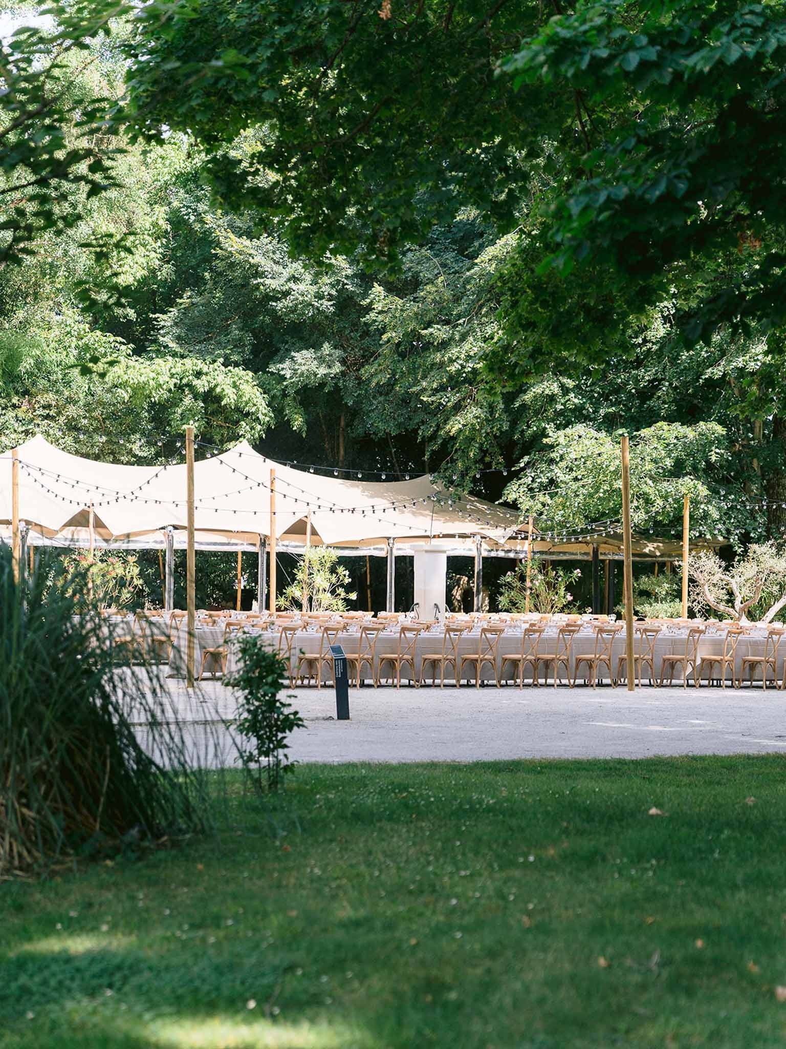 Reception marquee with festoon lights in garden at Chateau des Barrenques