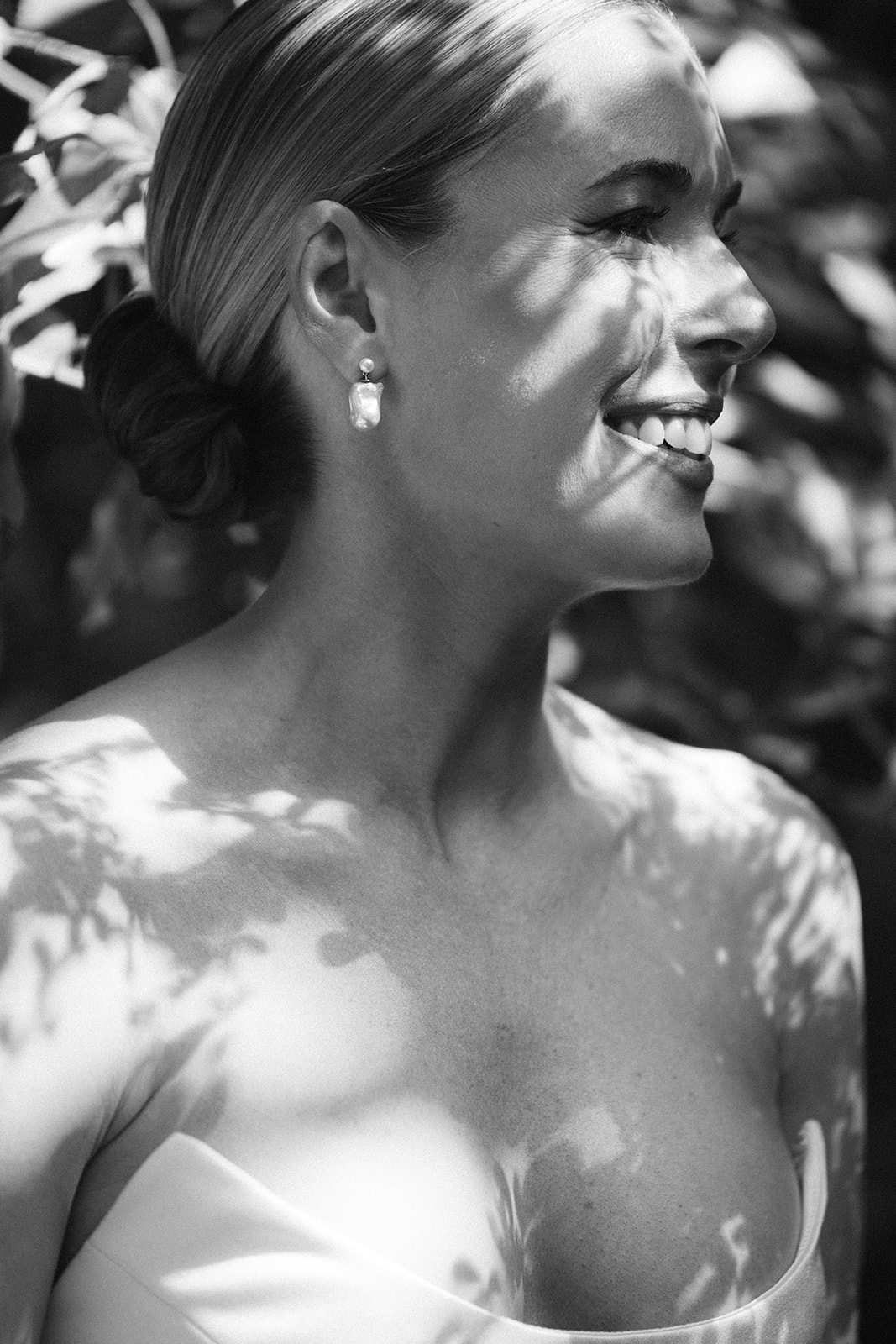 Black and white close-up of the bride with slick low bun and pearl drop earring at Restaurant l'Ile, Paris