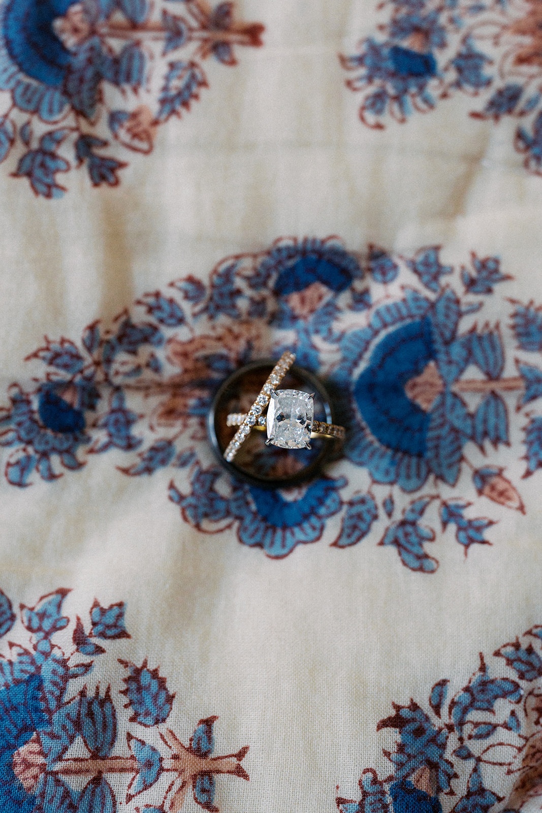 Engagement ring with diamond pavé band on a blue and ivory block-print bedspread