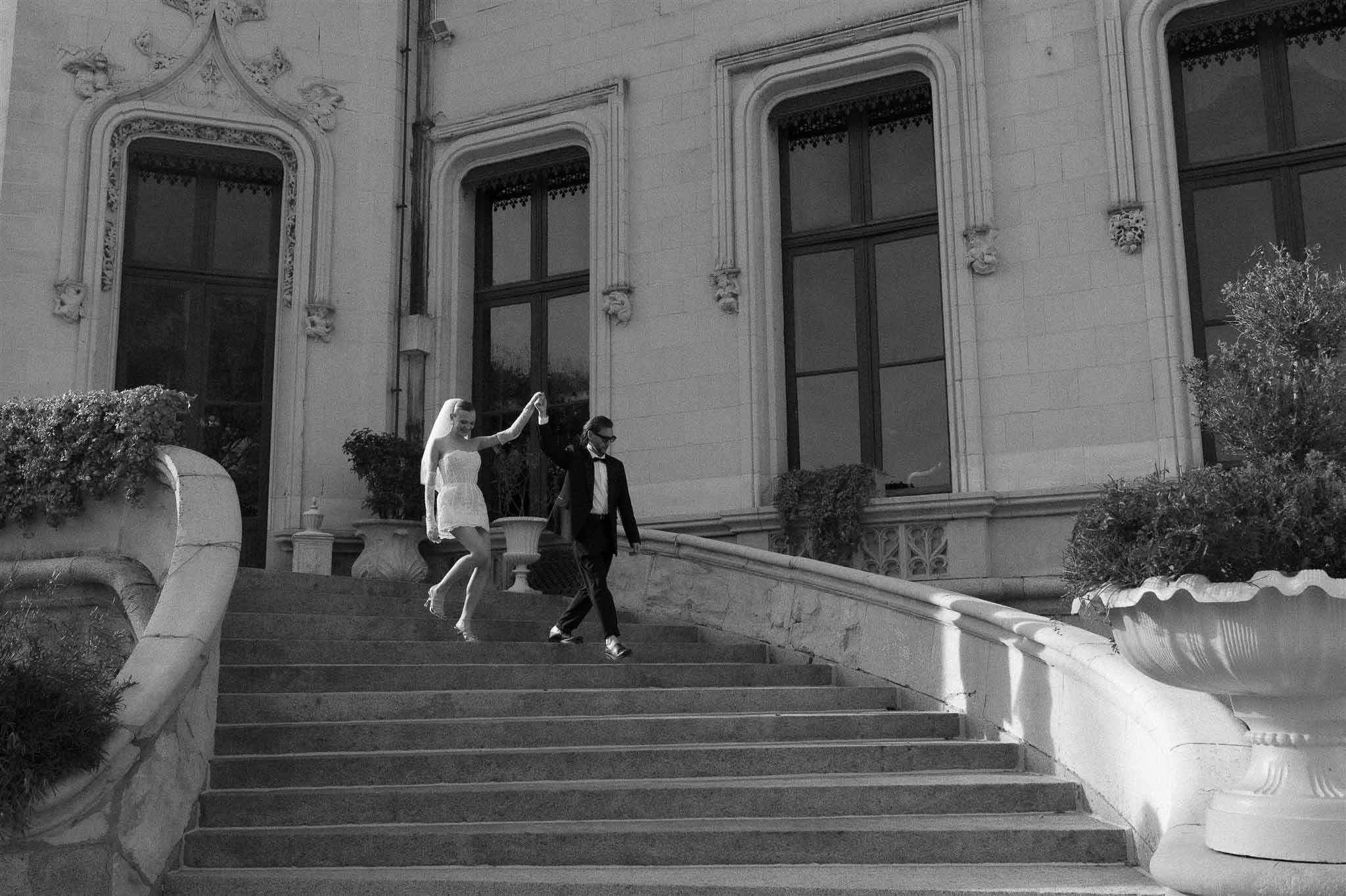 Black and white photo of bride and groom walking hand in hand
