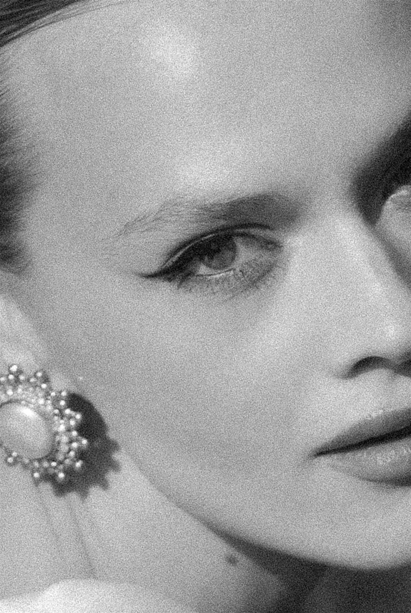 Black and white extreme close-up of bride's face showing pearl cluster earring and defined liner
