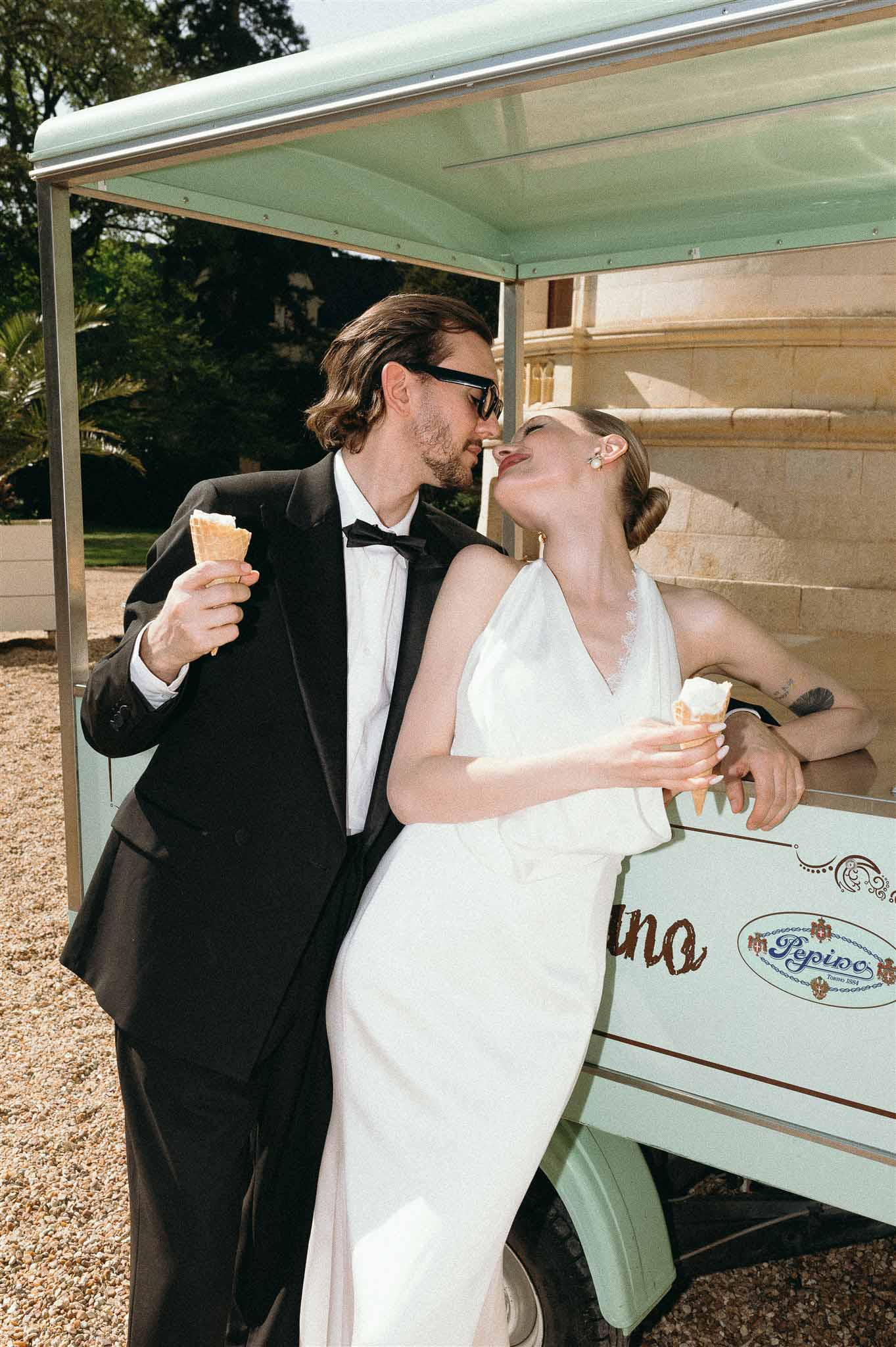 Couple laughing with gelato at mint-green vintage ice cream cart on chateau gravel courtyard