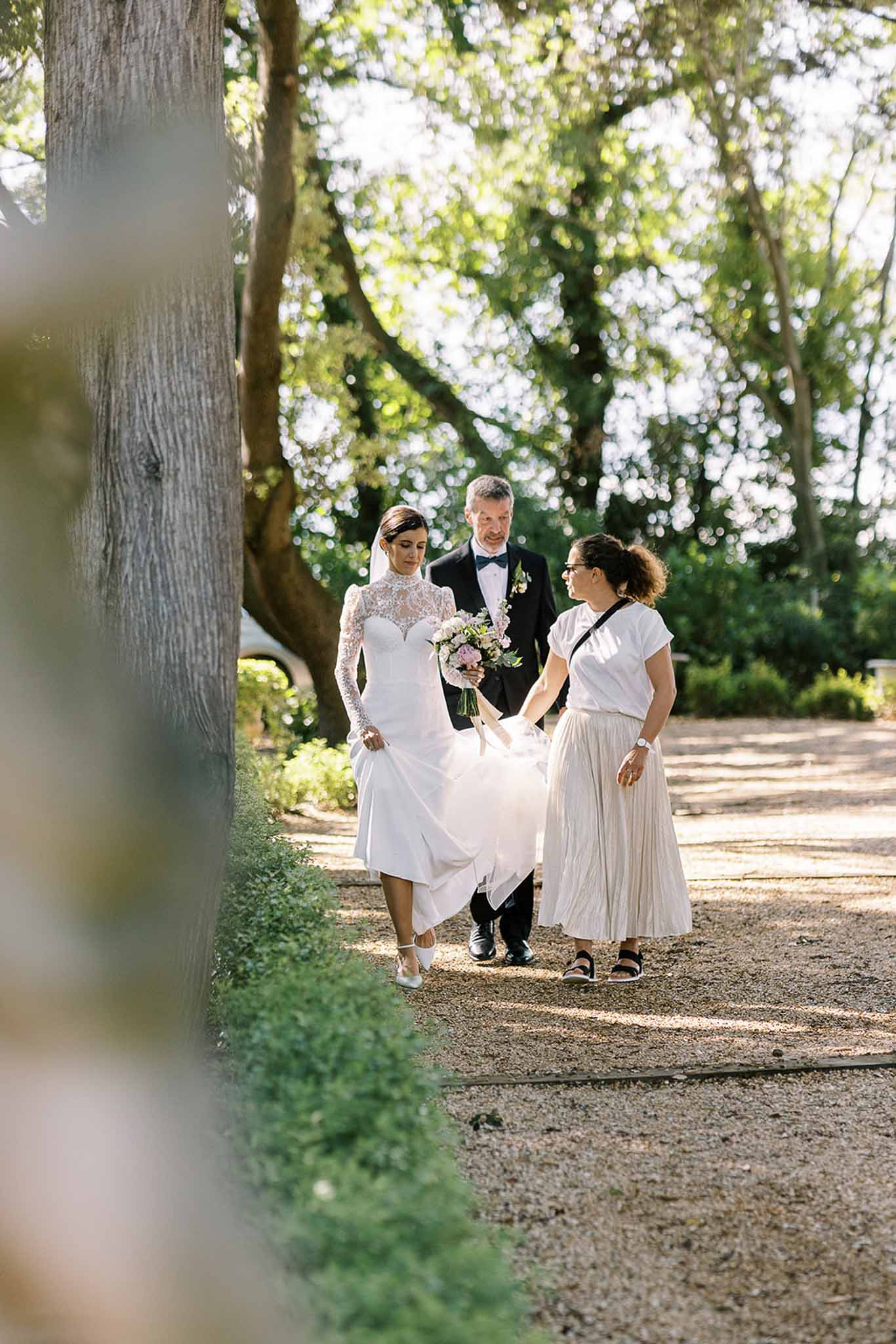 Bride and groom walking hand in hand in a garden