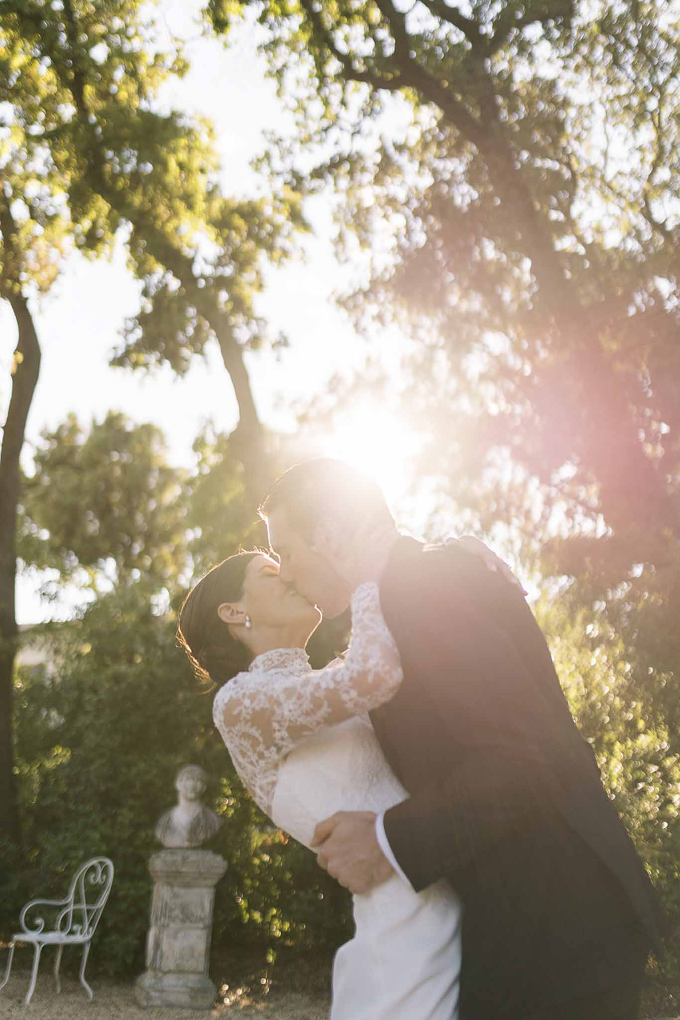 Bride and groom kissing in a garden