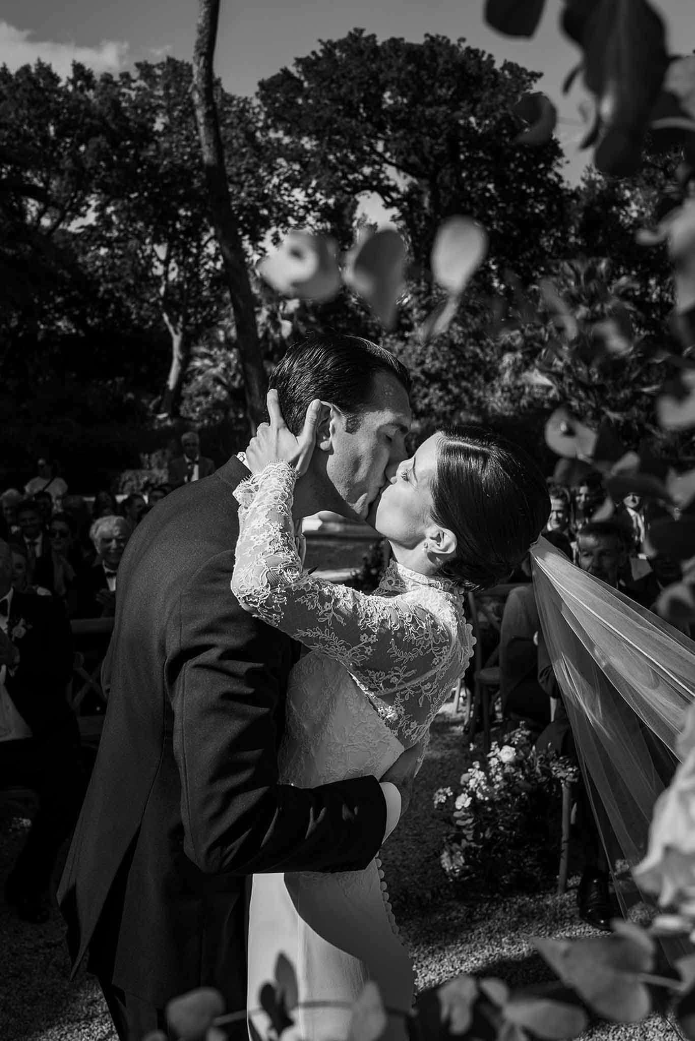 Black and white photo of wedding ceremony in a garden with white roses