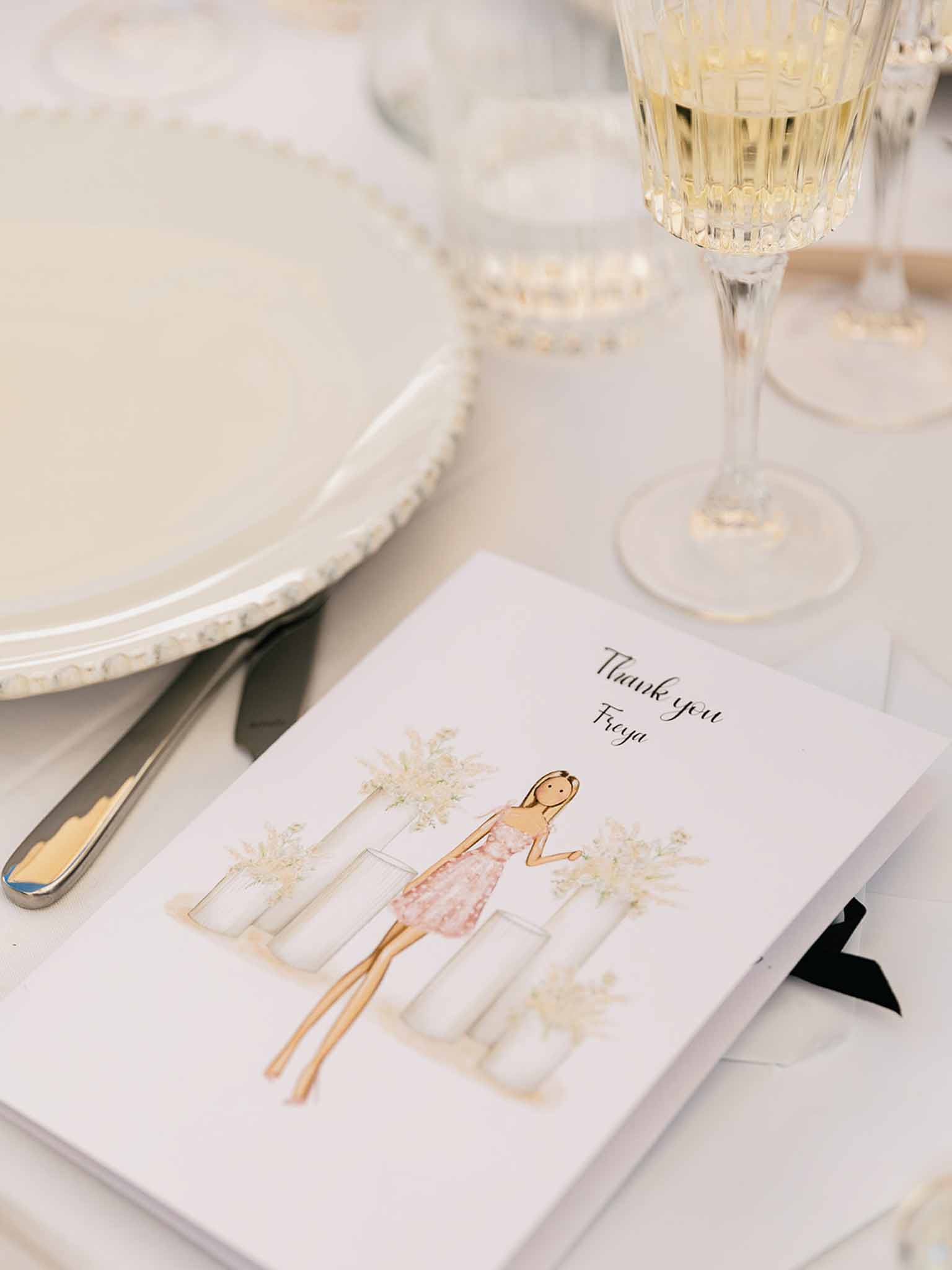 Watercolour illustrated thank-you card for Freya on gold-rimmed plate with crystal champagne flute