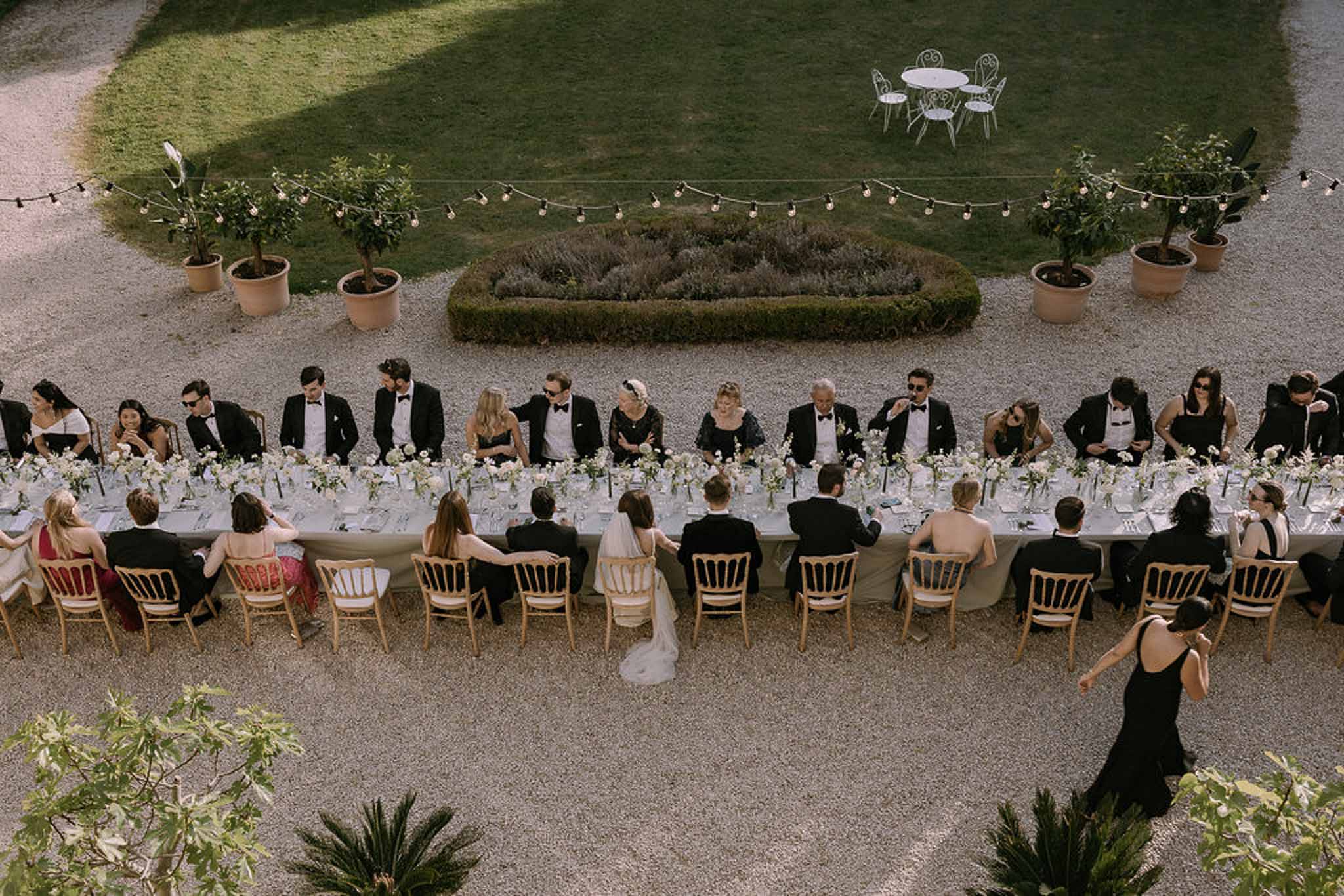 Wedding reception table setting in a garden with white roses