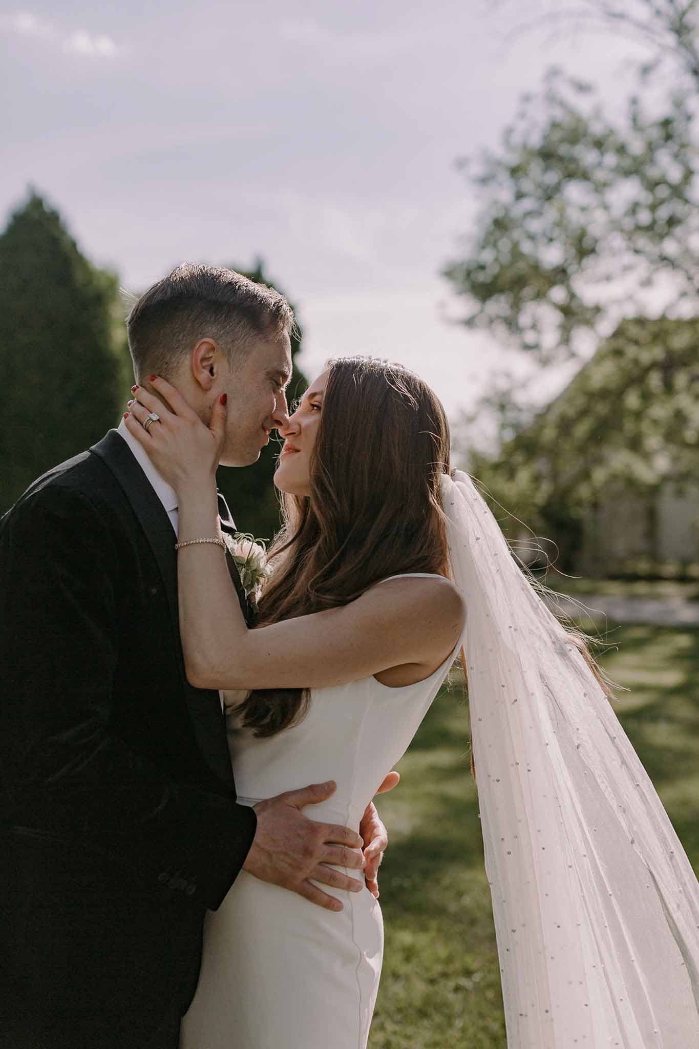 Bride and groom kissing in a garden