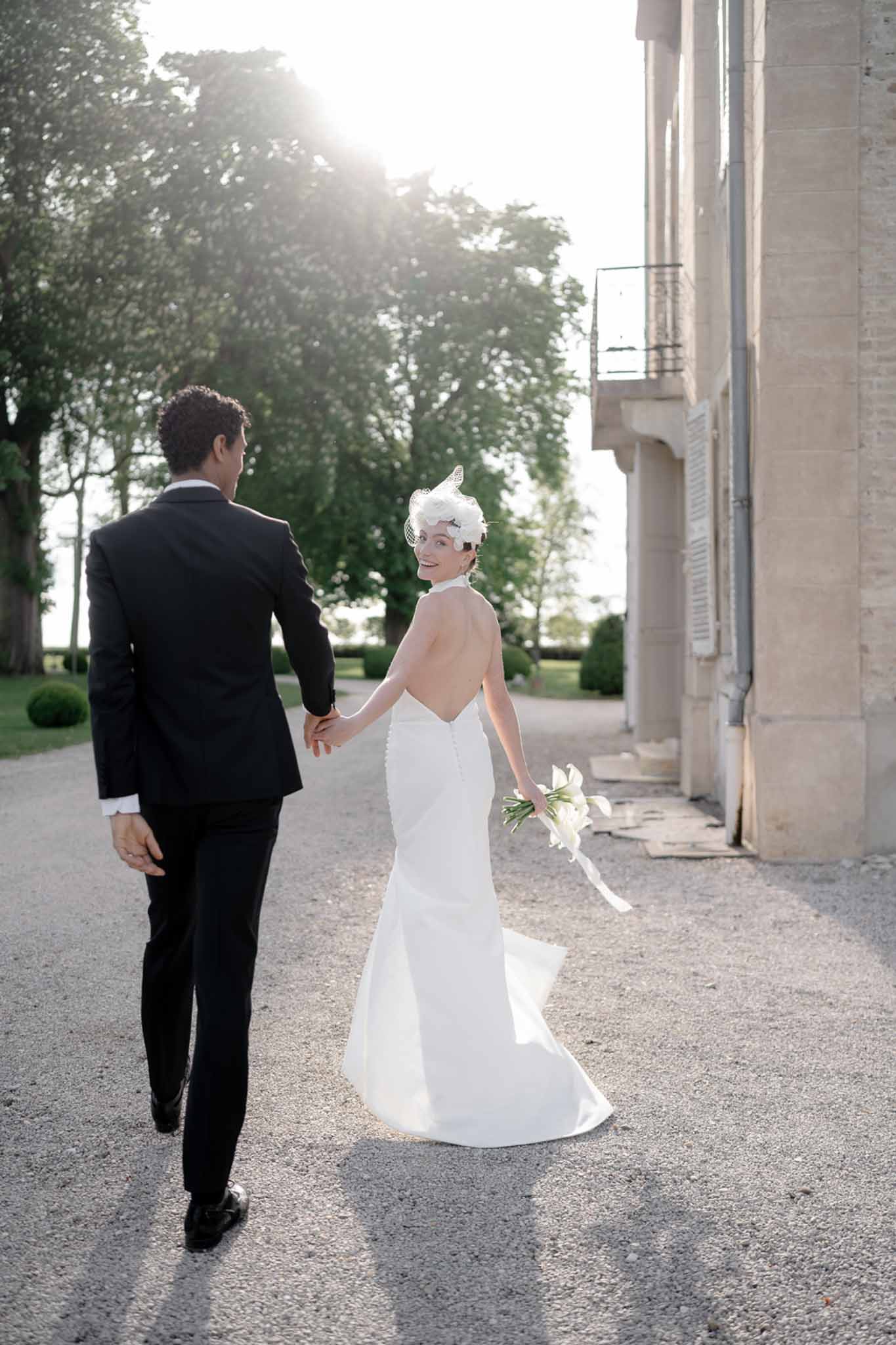 Black and white photo of bride and groom walking hand in hand