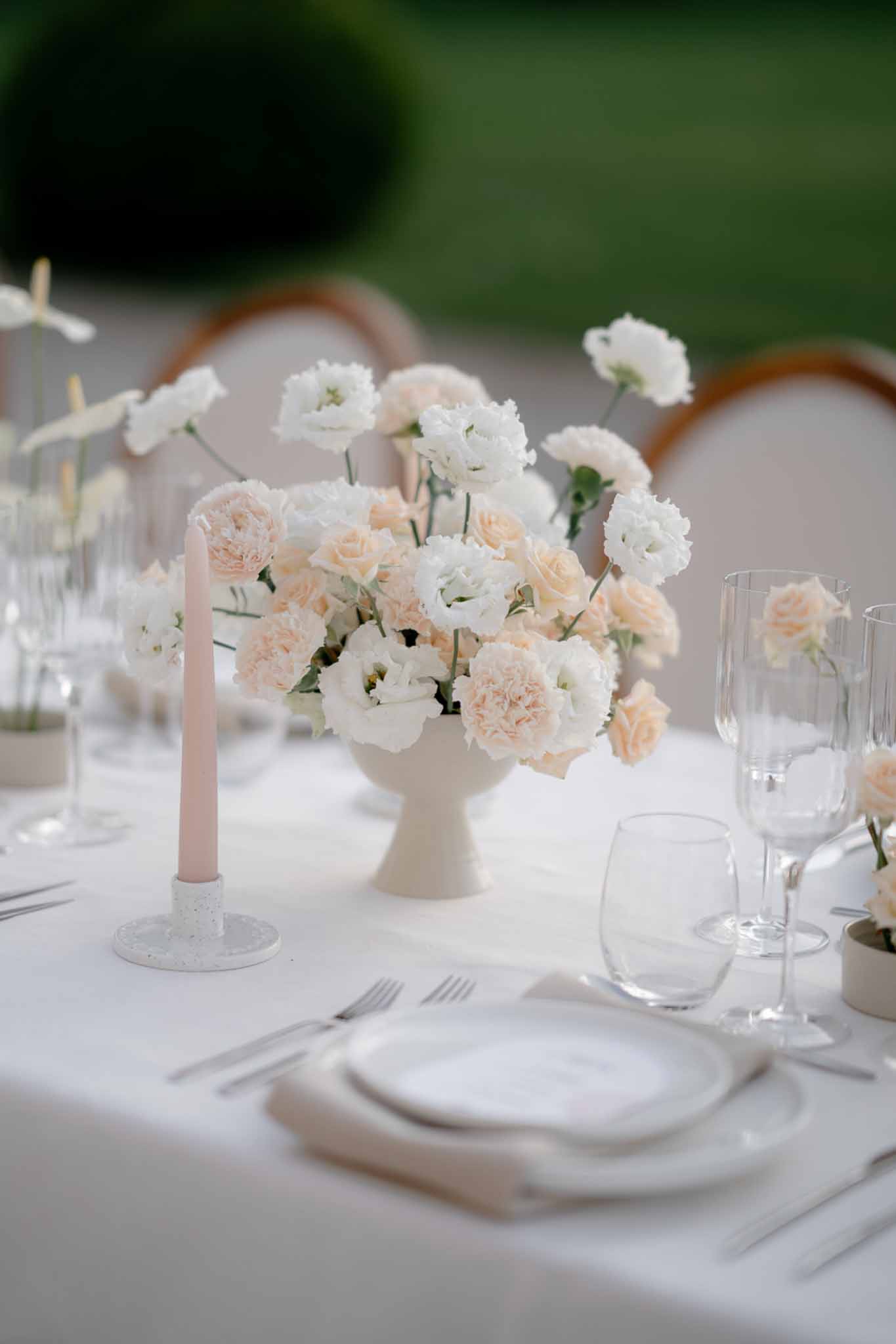 Wedding reception table setting in a garden with white roses