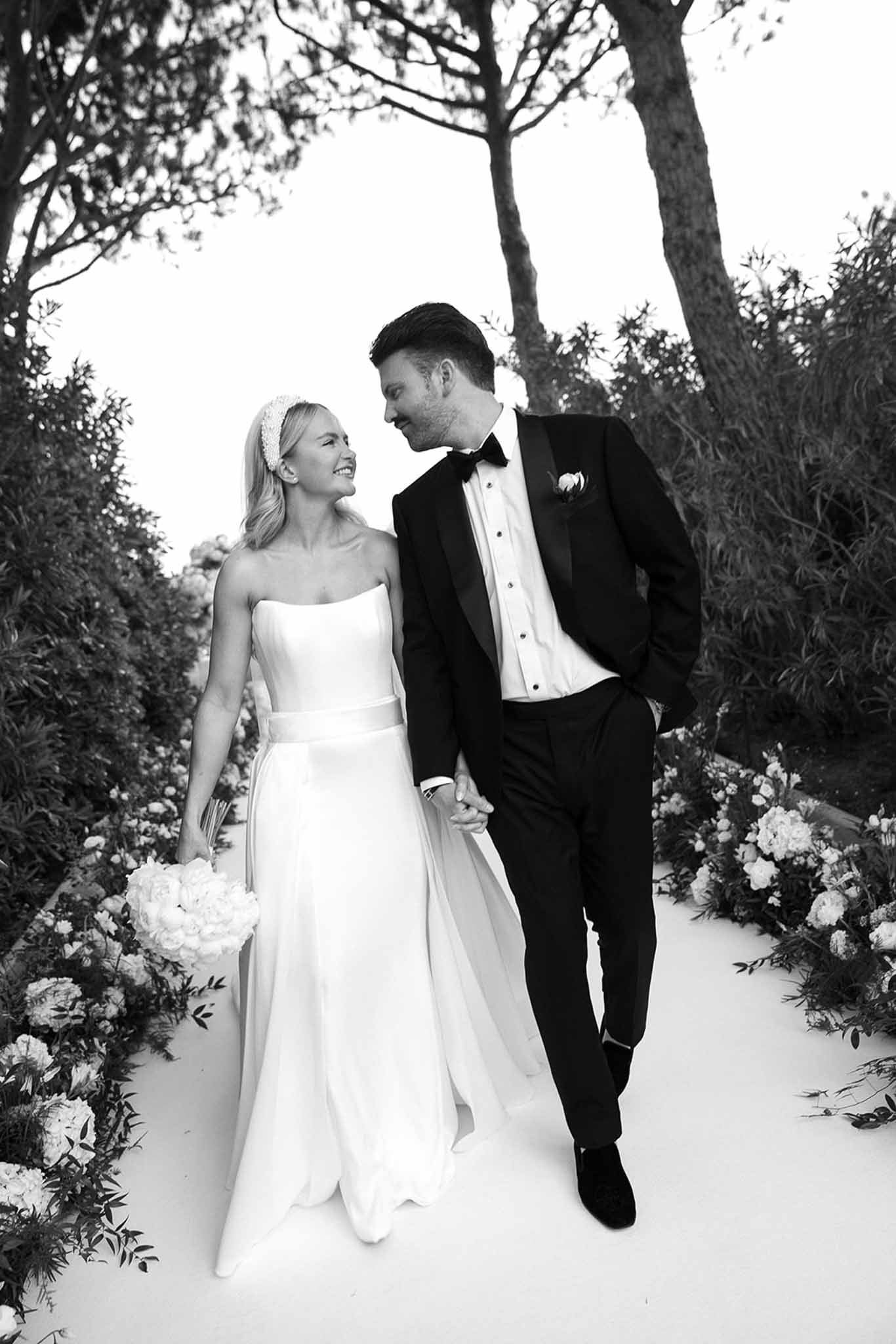 Black and white photo of wedding ceremony in a garden with white roses