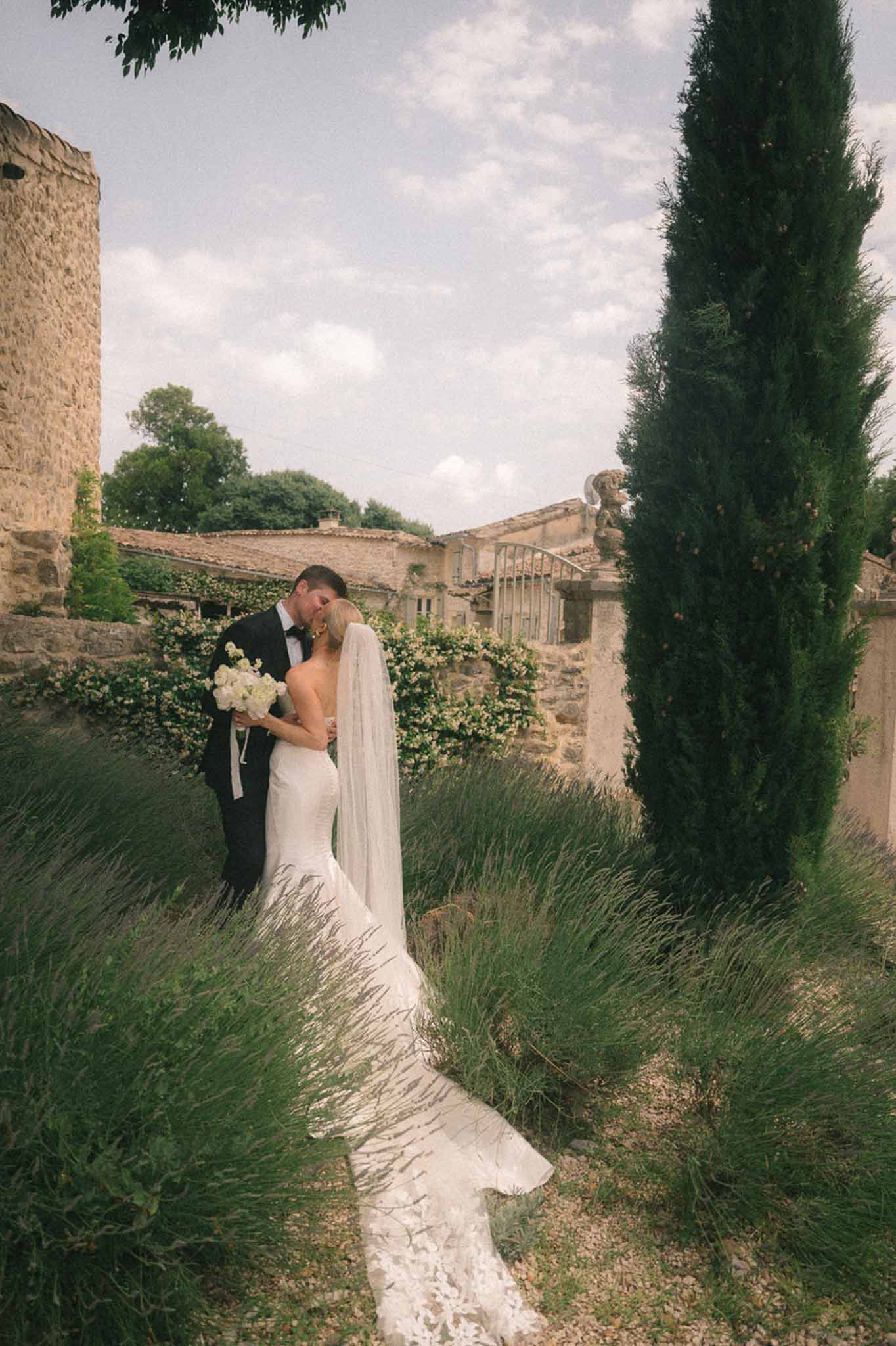 Bride and groom kissing in a garden