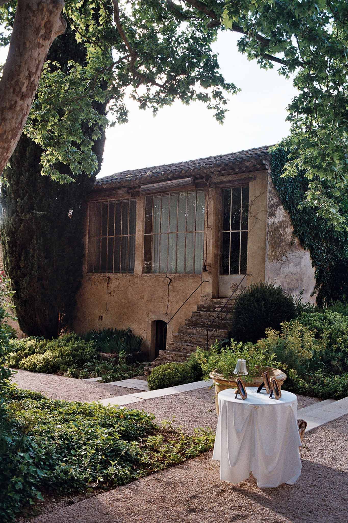 Provencal mas garden with cocktail table greenhouse windows stone staircase and gravel path with hedging