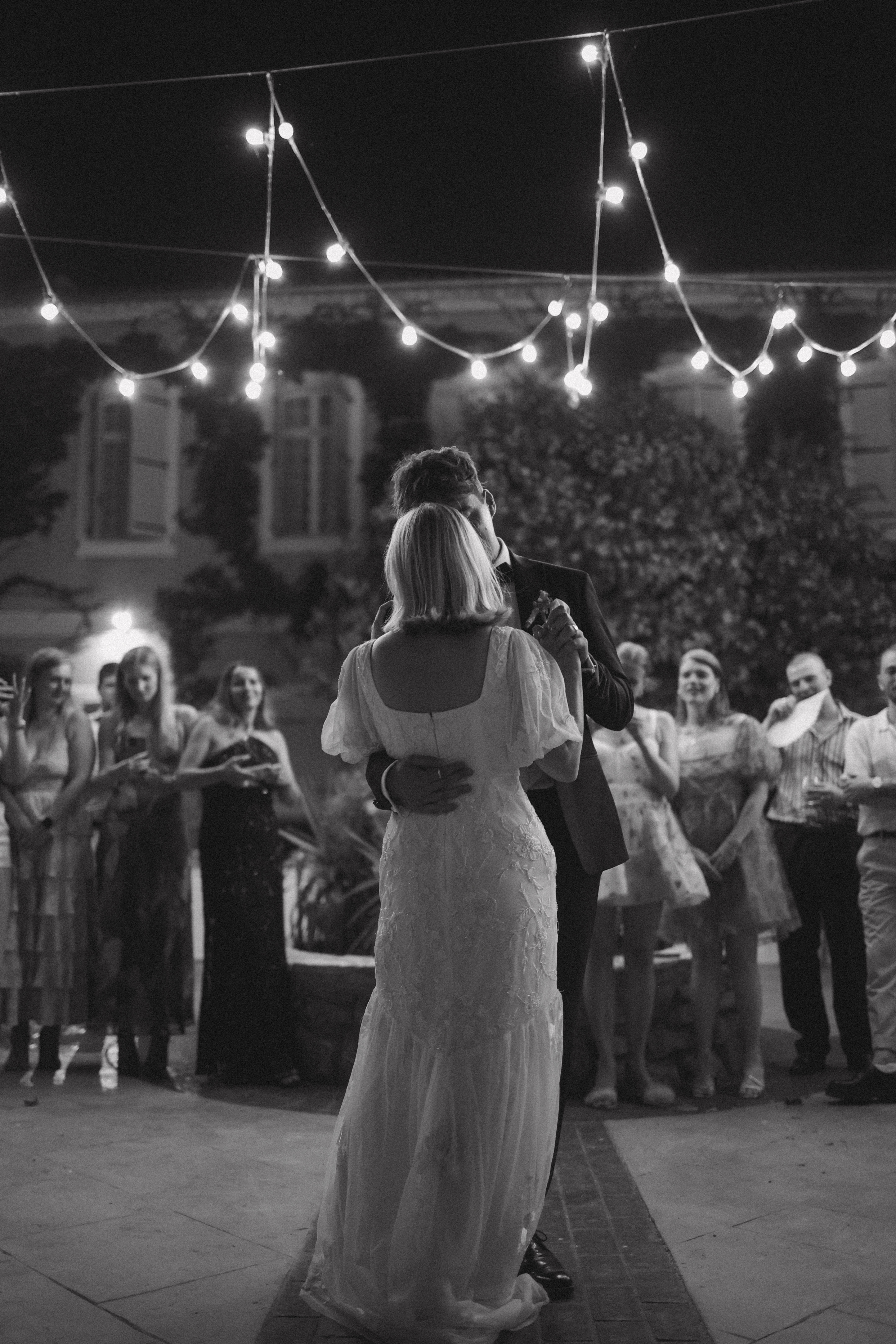 Black and white first dance under festoon lights at Chateau du Puits es Pratx, Ginestas
