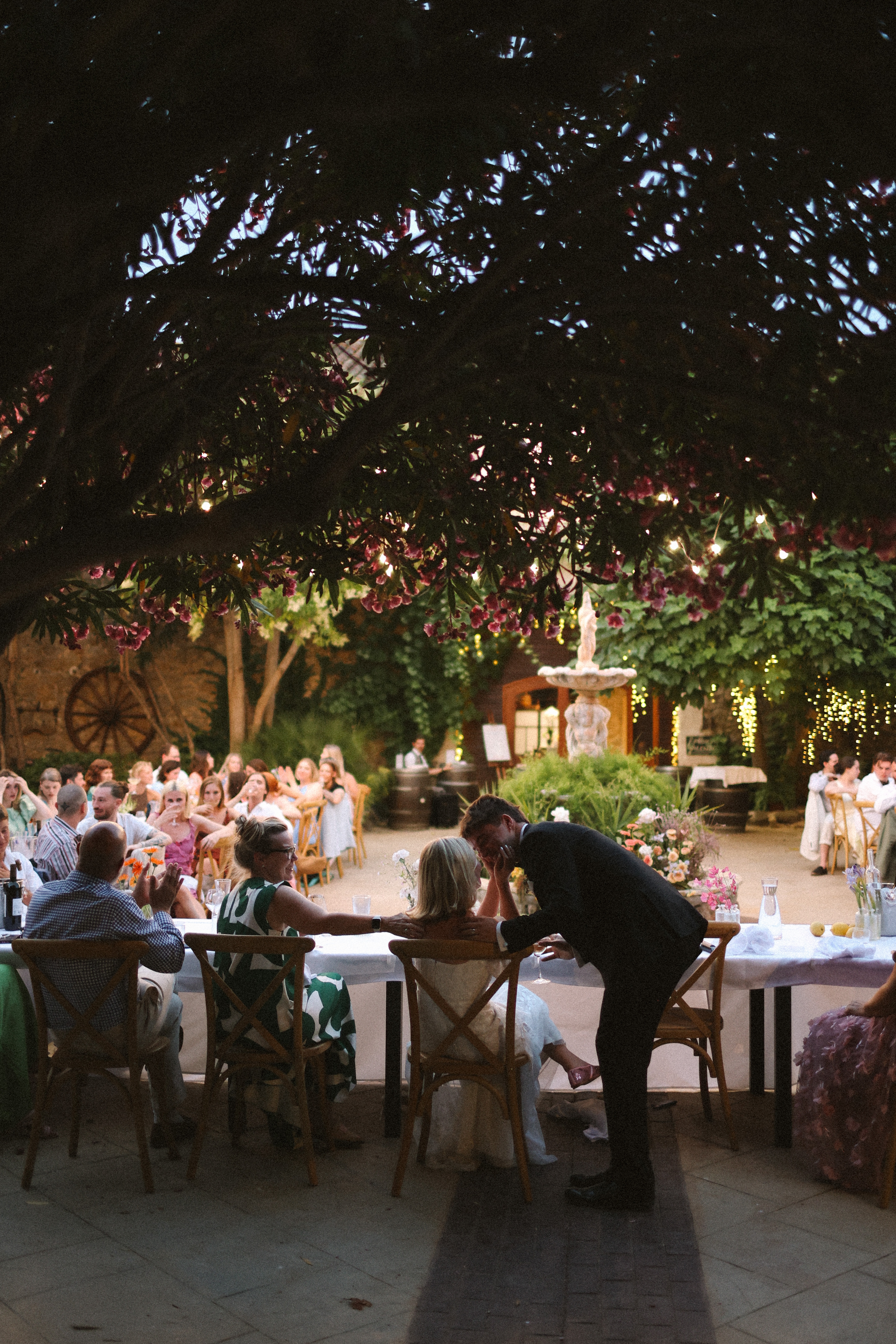 Couple kiss at courtyard dining table at Chateau du Puits es Pratx, Ginestas