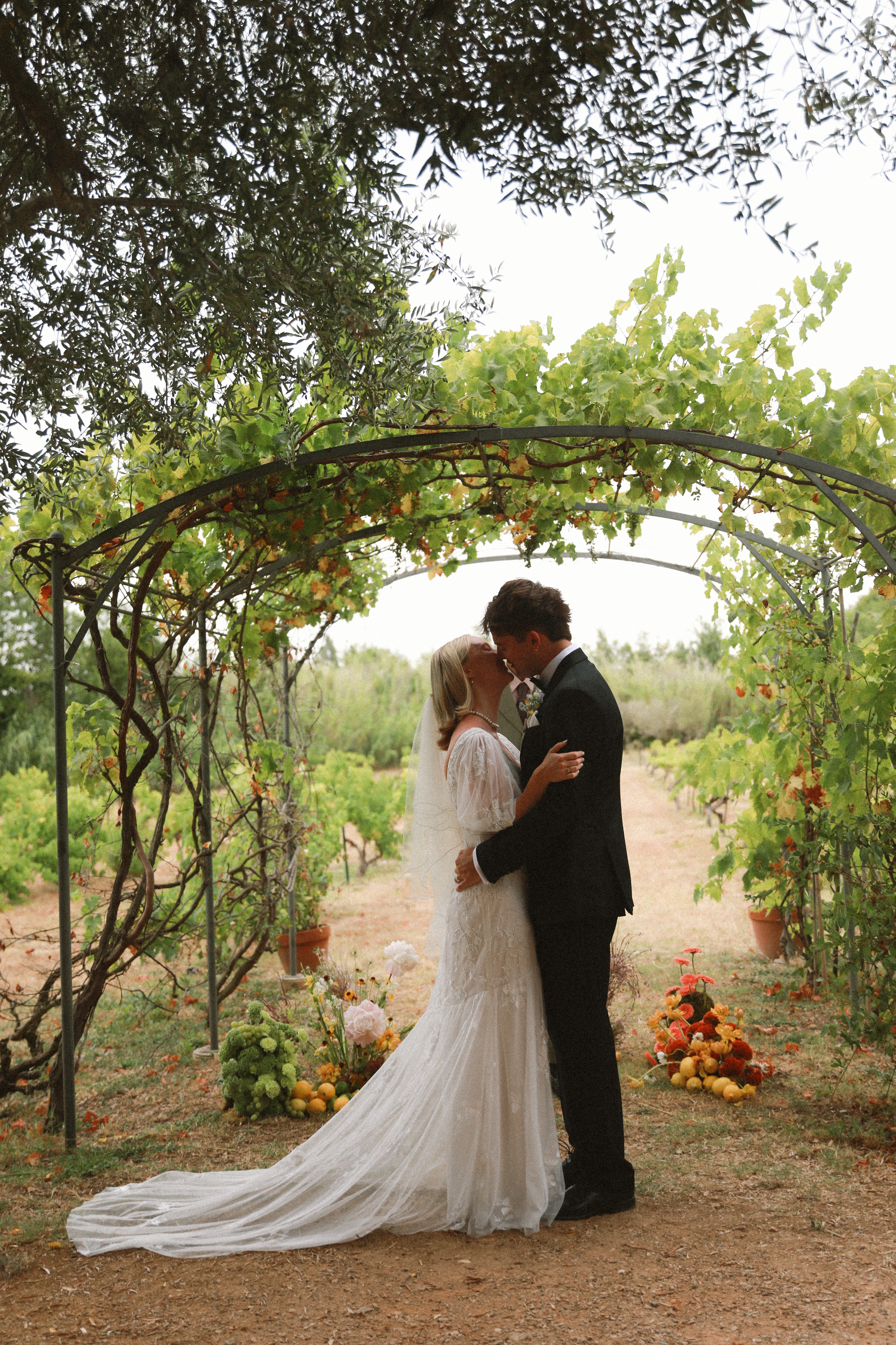 First kiss under vineyard arch at Chateau du Puits es Pratx, Ginestas