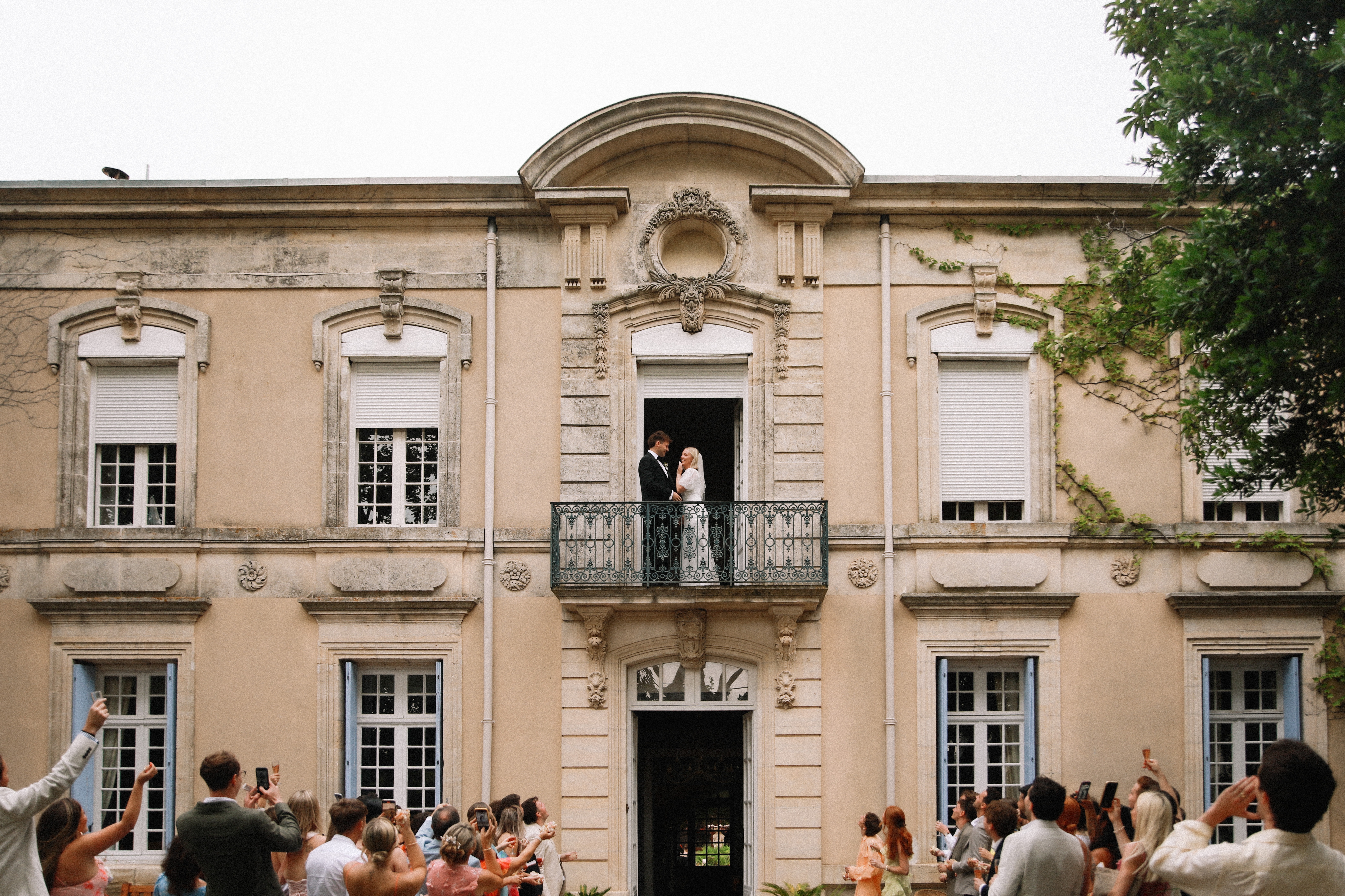 Couple on balcony with guests below at Chateau du Puits es Pratx, Ginestas
