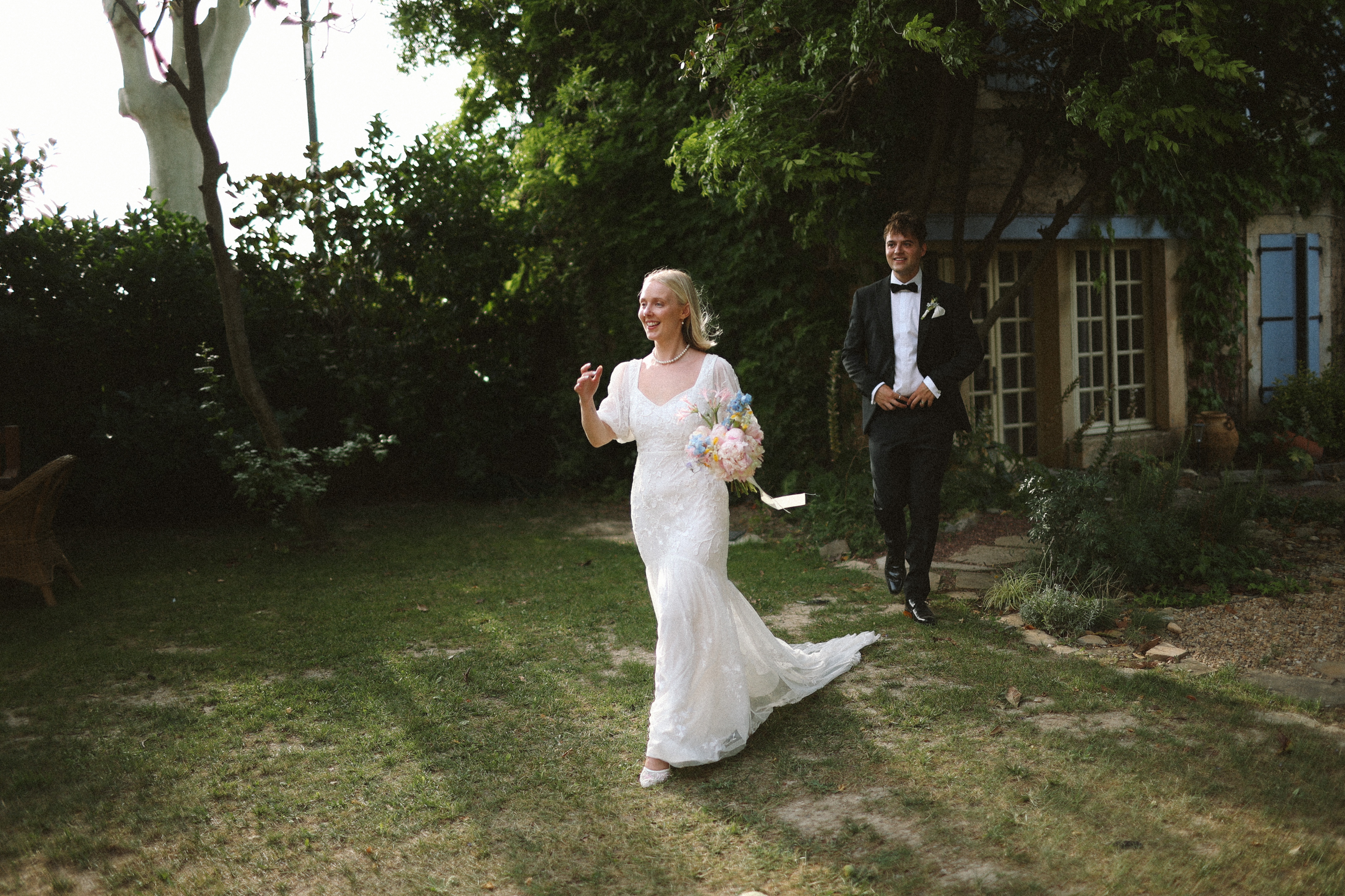 Bride walking across lawn with groom at Chateau du Puits es Pratx, Ginestas