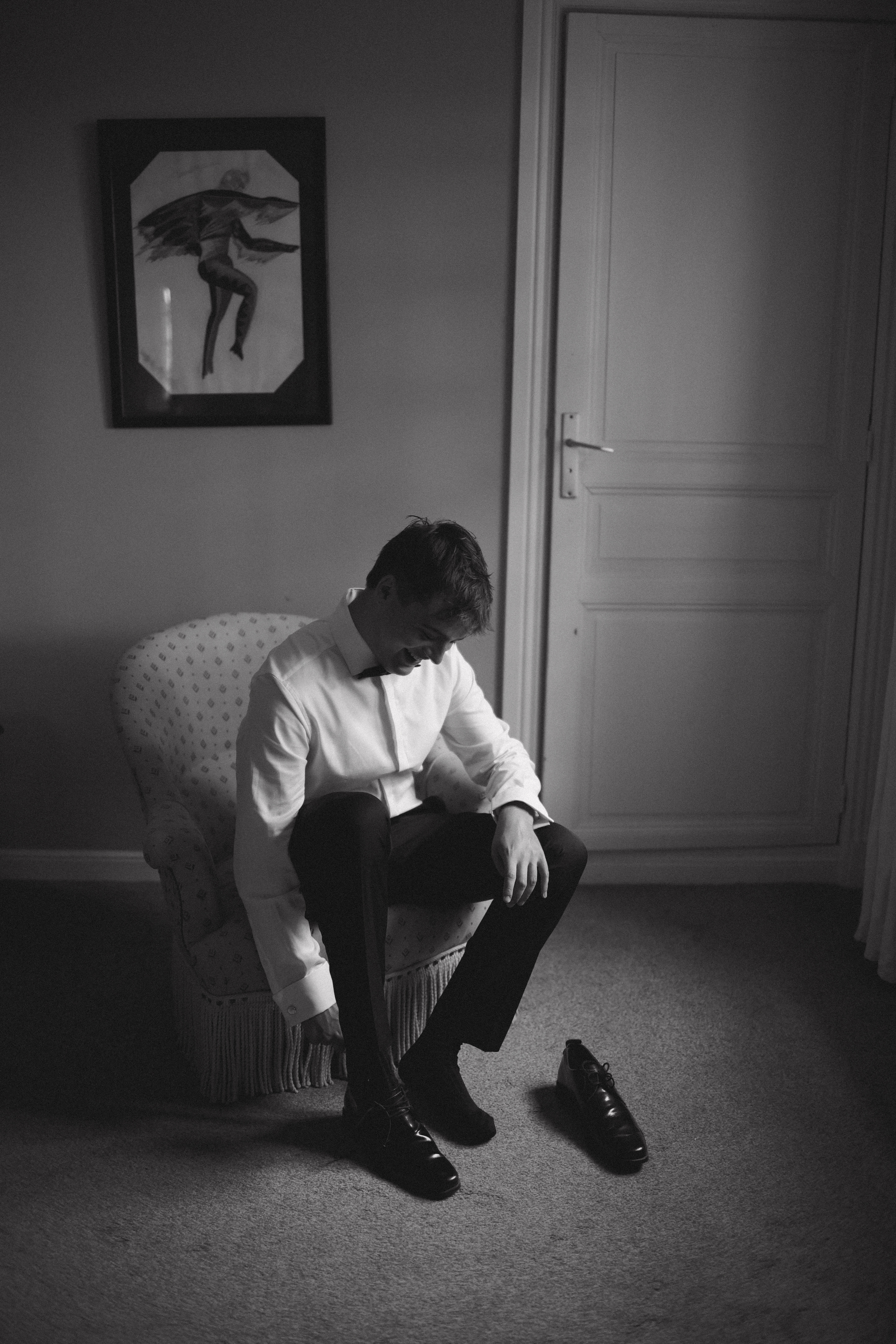 Groom putting on shoes in bedroom at Chateau du Puits es Pratx, Ginestas