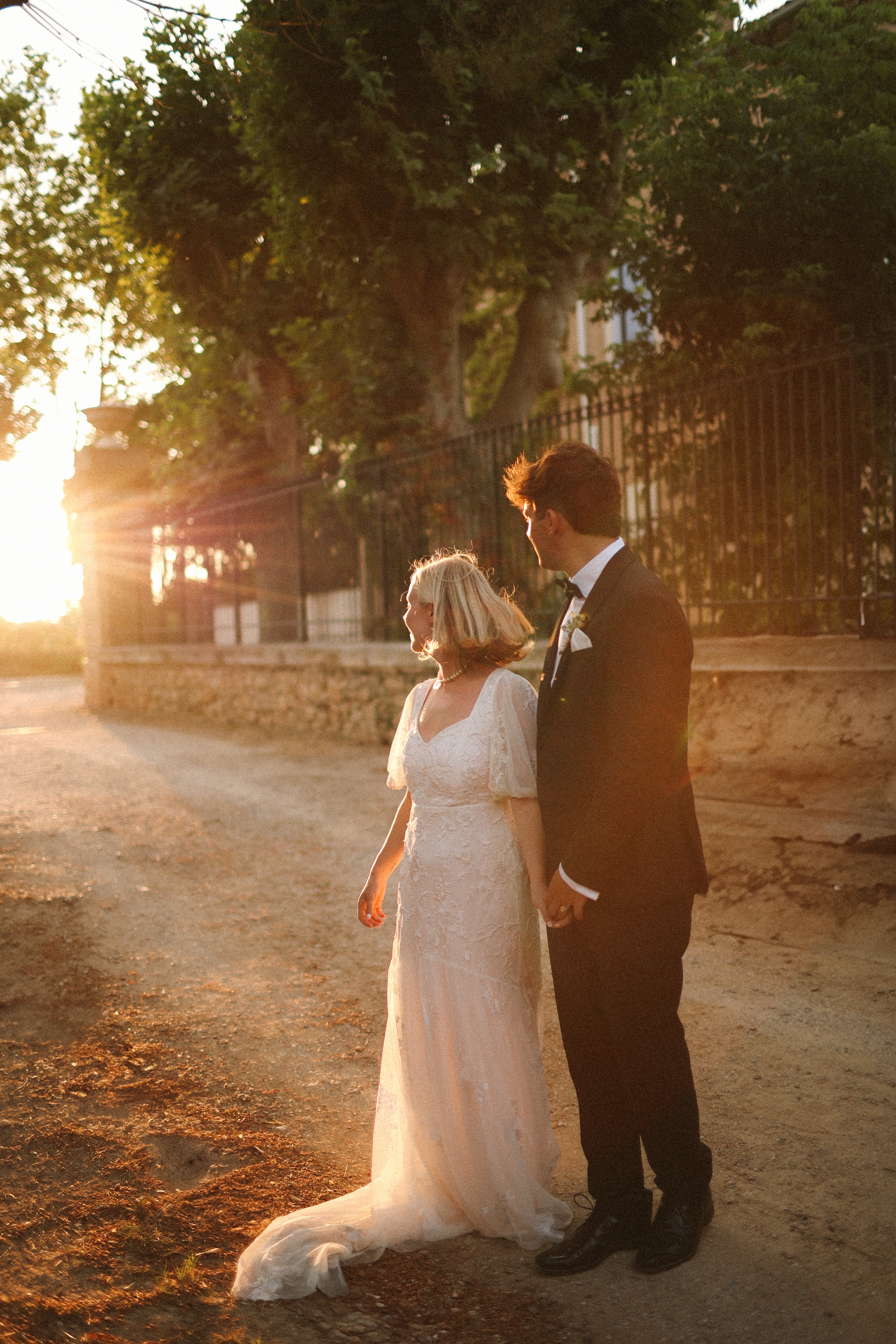Couple holding hands at sunset on gravel path at Chateau du Puits es Pratx, Ginestas