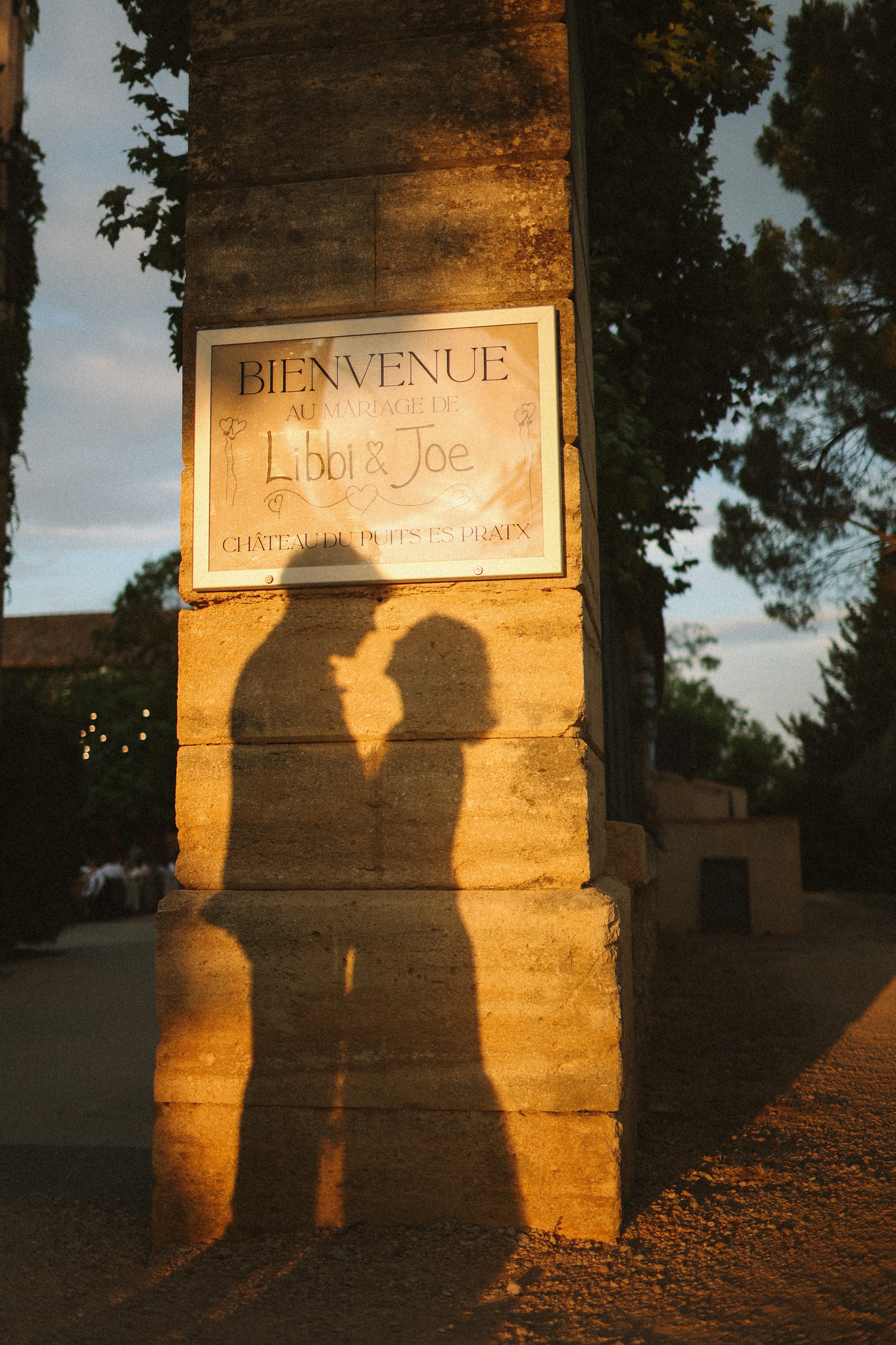 Couple shadow beside welcome sign at Chateau du Puits es Pratx, Ginestas