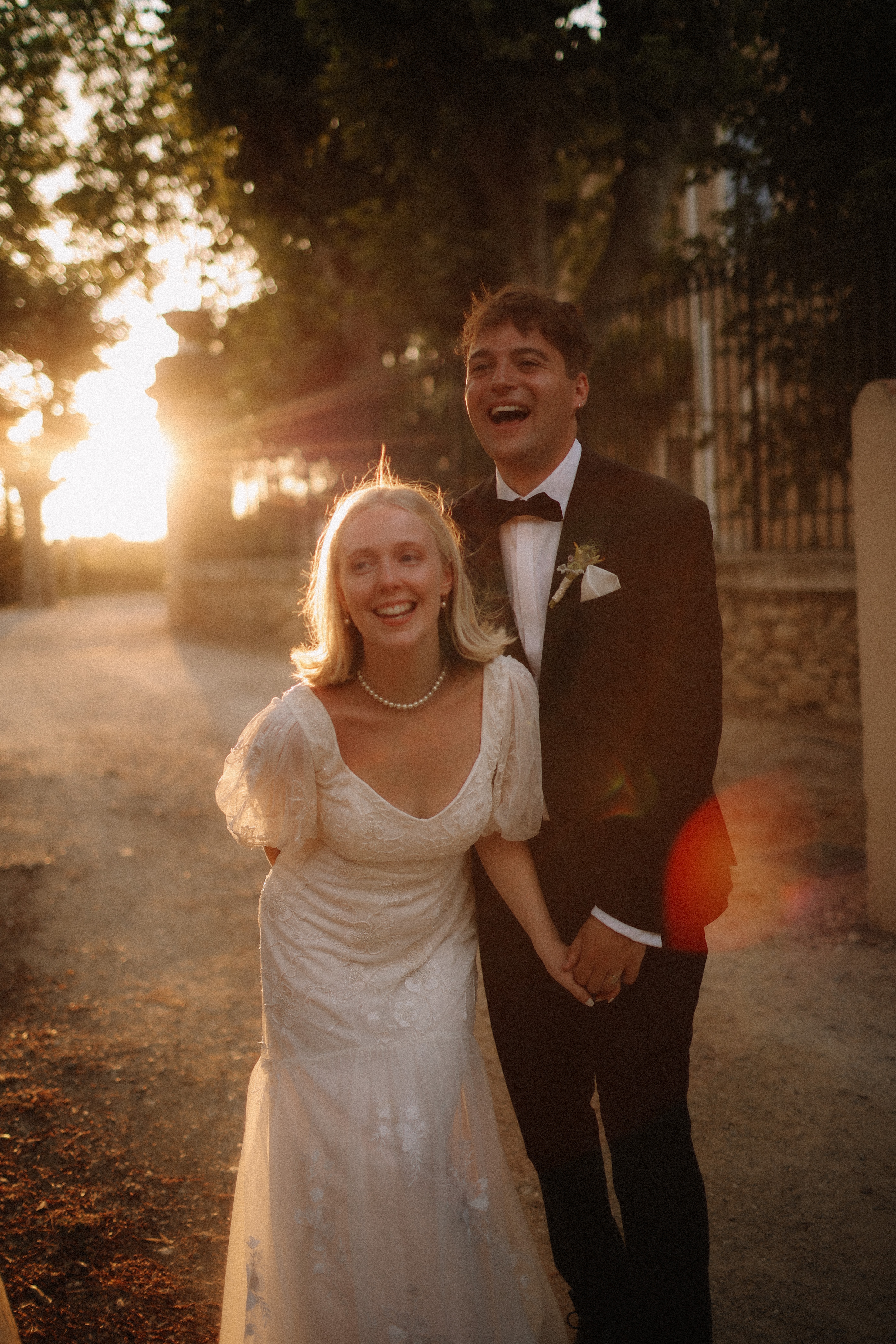 Couple laughing hand in hand at golden hour at Chateau du Puits es Pratx, Ginestas