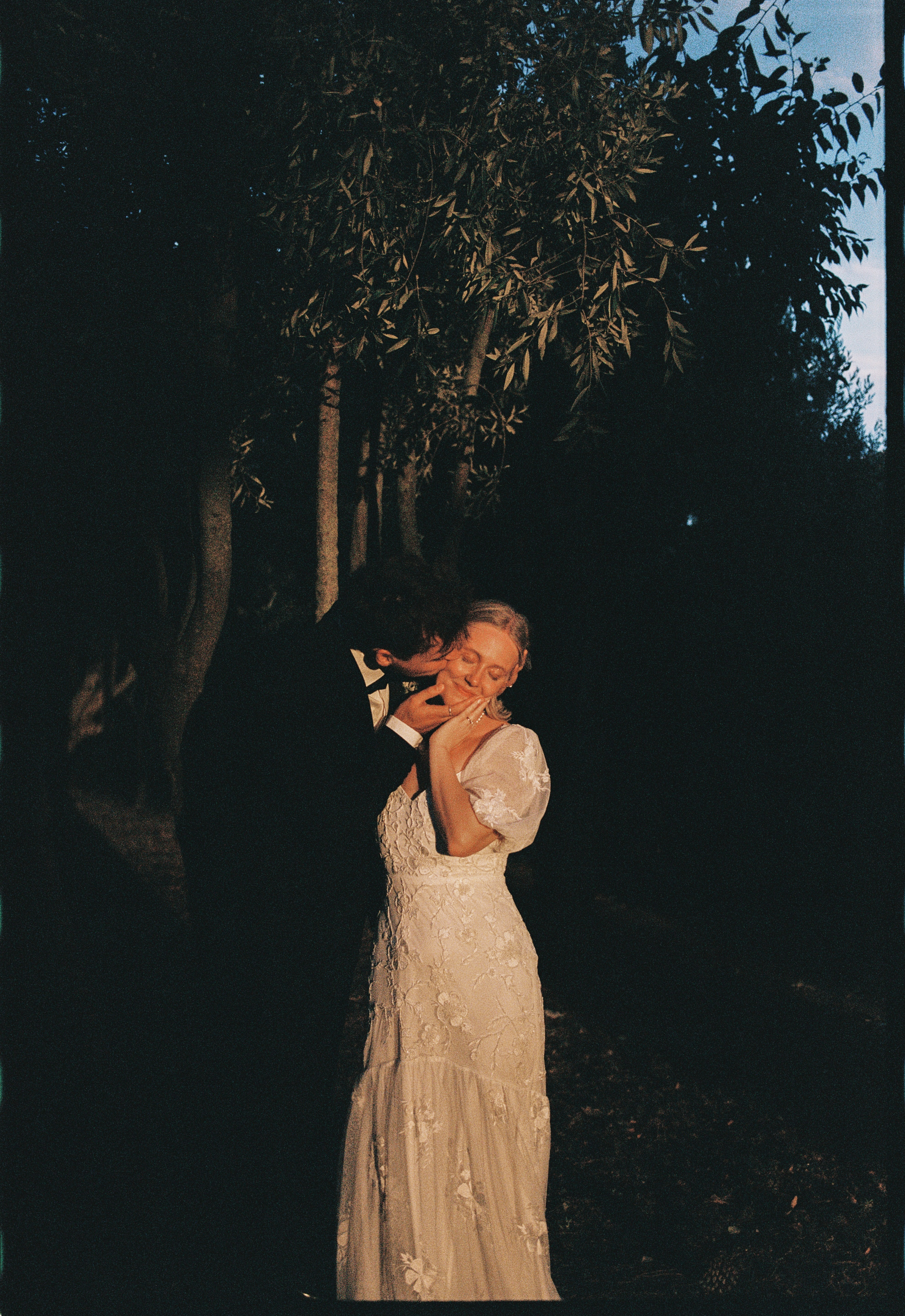 Couple kiss beneath olive branches at blue hour at Chateau du Puits es Pratx, Ginestas