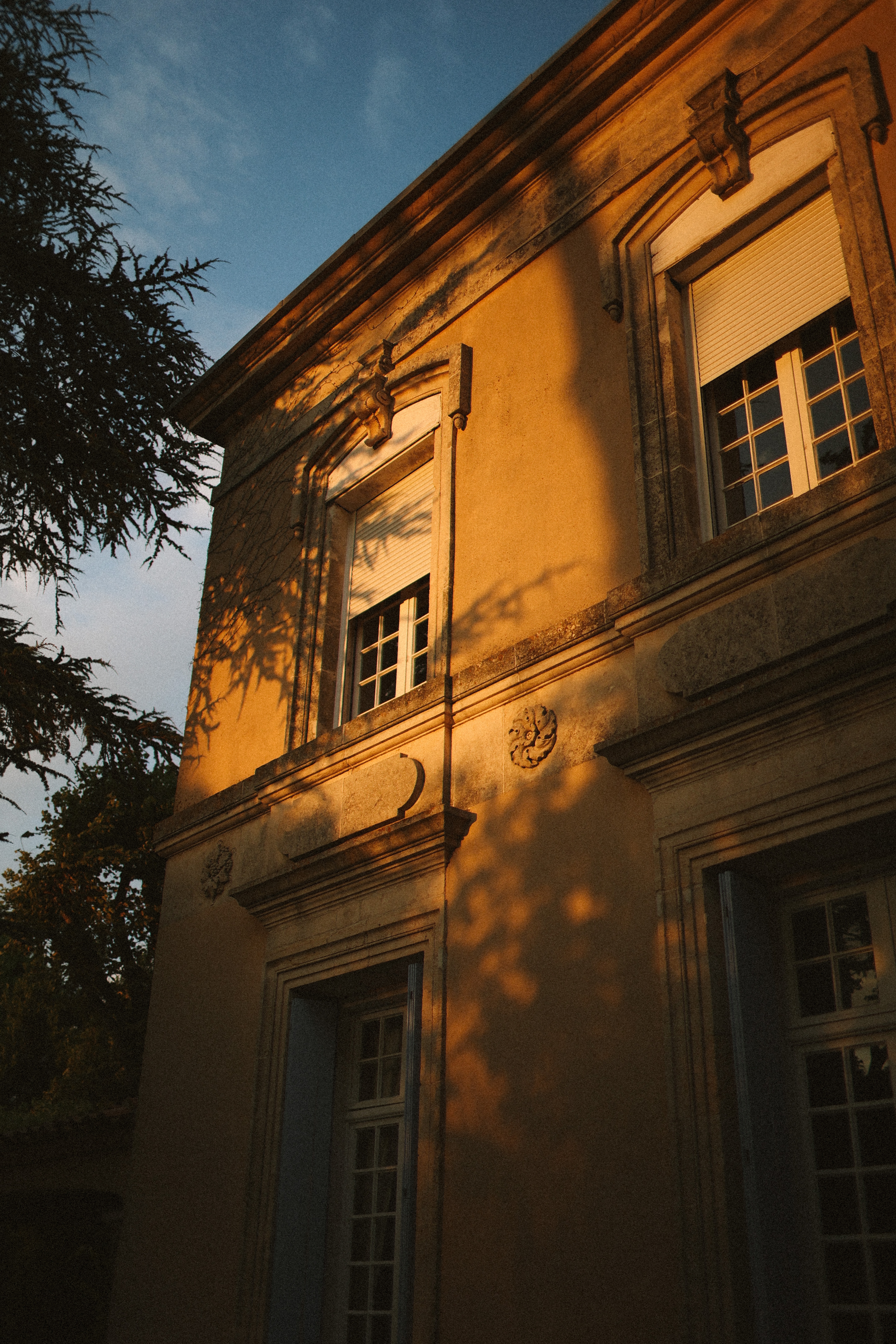Chateau facade with tree shadows at golden hour at Chateau du Puits es Pratx, Ginestas