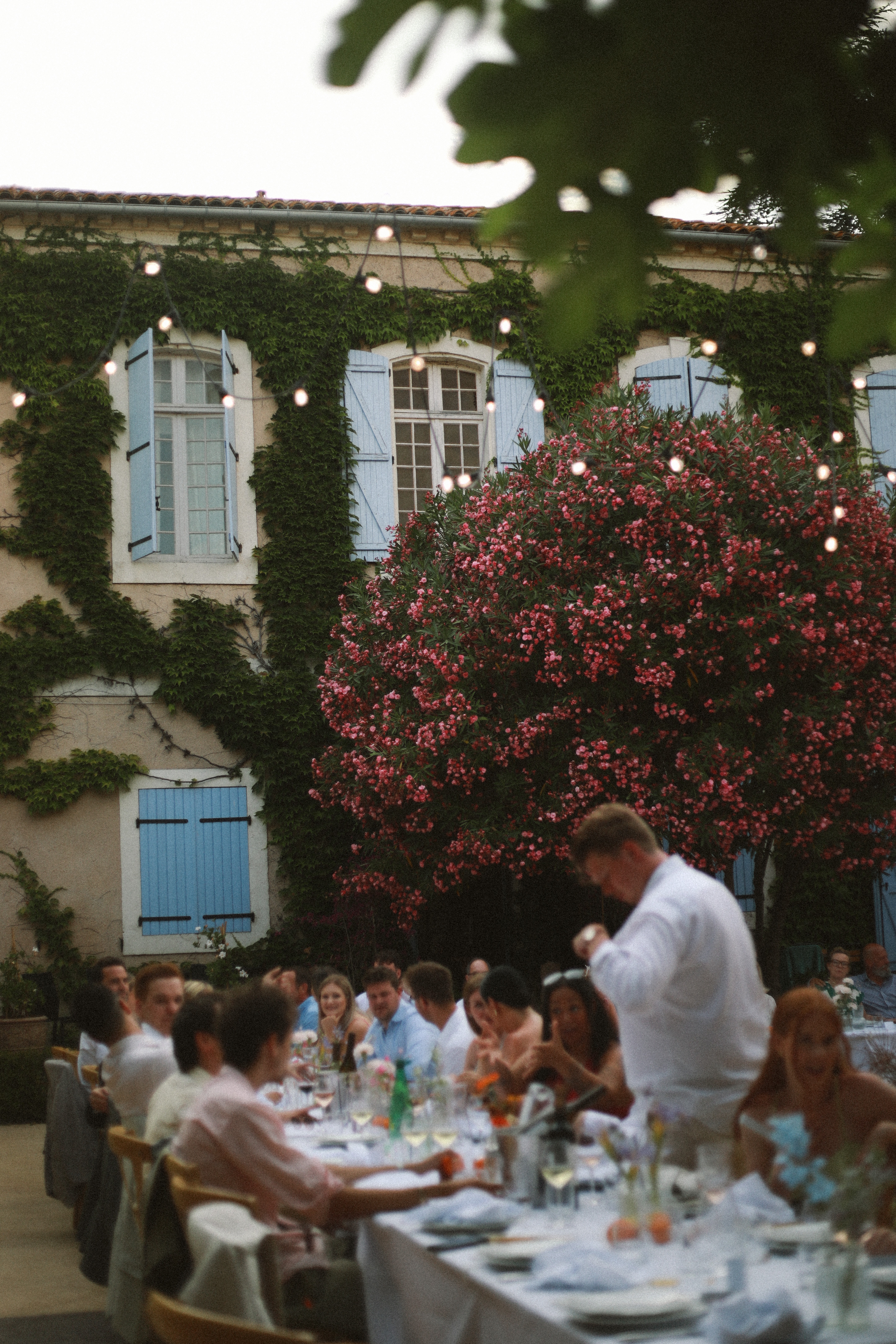 Courtyard reception dinner by ivy wall at Chateau du Puits es Pratx, Ginestas