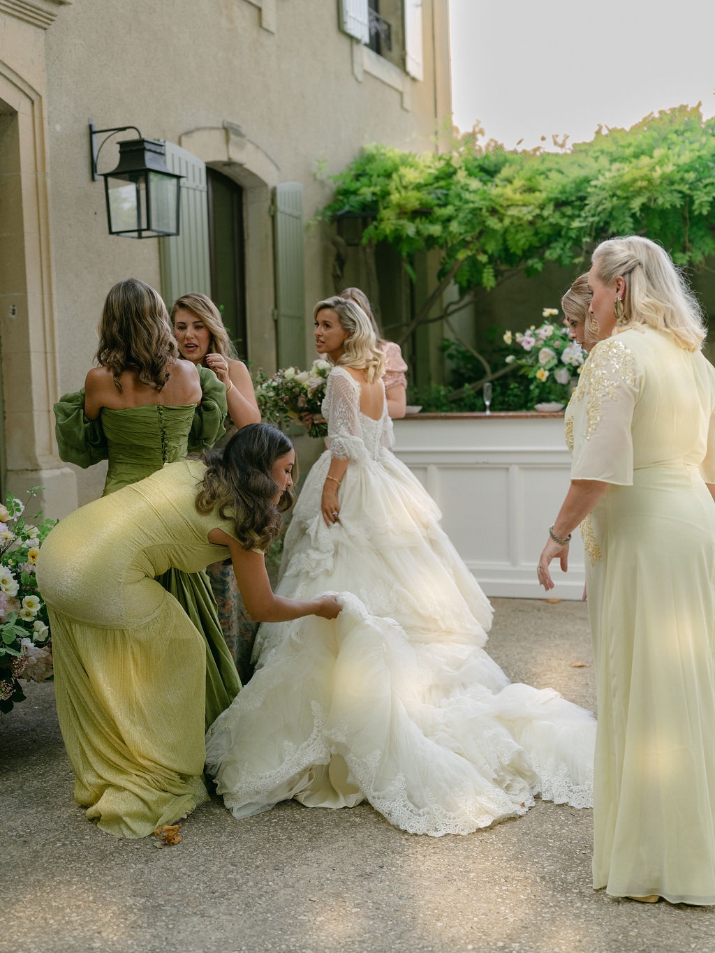 bridesmaids adjusting the bride's gown on the lawn at La Bastide de Laurence, Provence