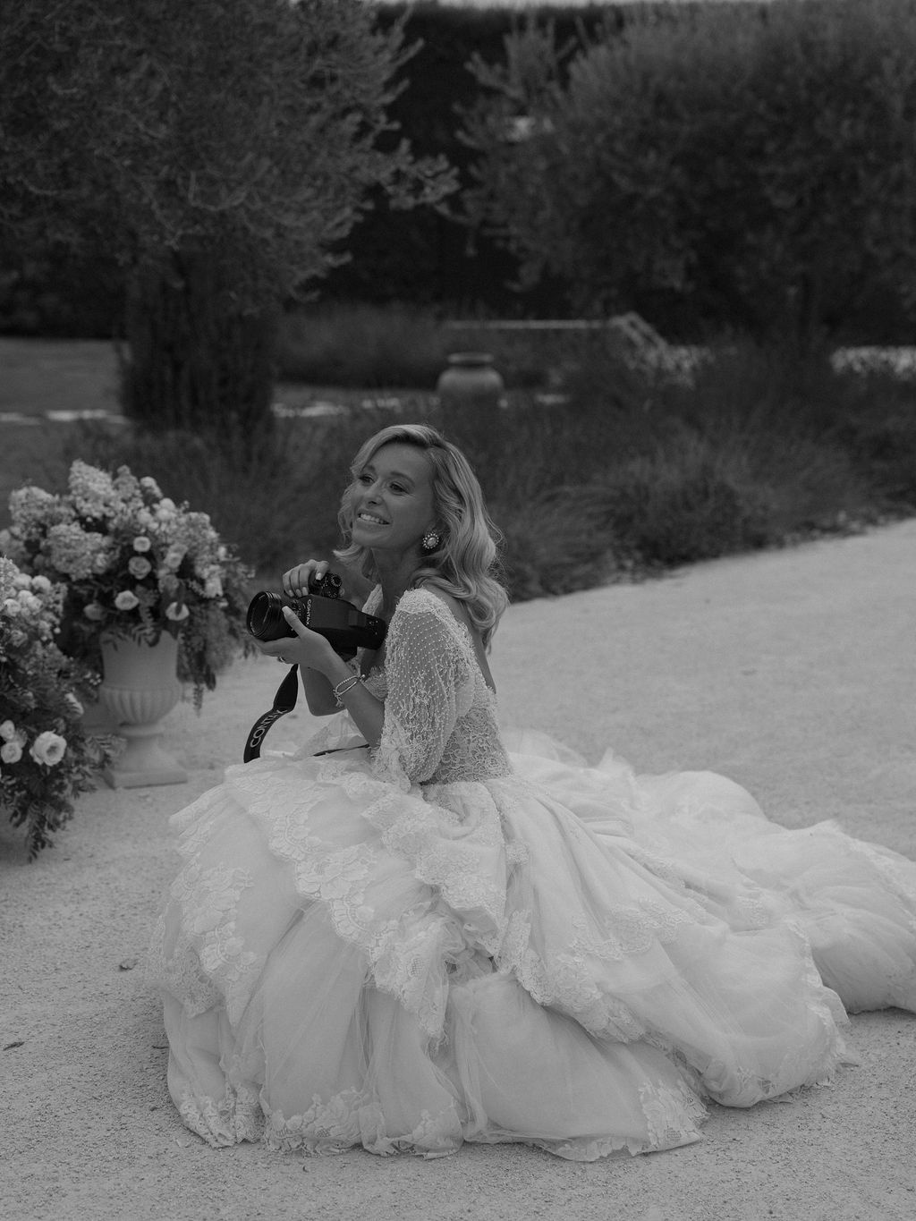 bride laughing with her camera beside an urn at La Bastide de Laurence, Provence