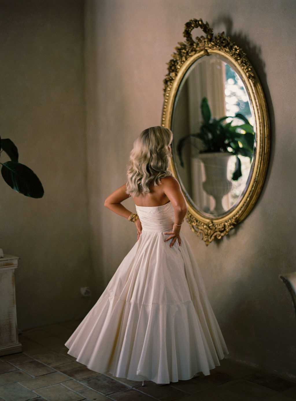 bride in Dior reception gown by a gilt mirror at La Bastide de Laurence, Provence